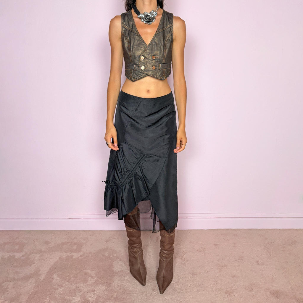 Vintage 2000s black midi skirt featuring an asymmetric deconstructed silhouette with diagonal paneling, gathered ruching, a sculptural draped insert, and a sheer black underlayer. Elegant dark avant-garde style, perfect for formal outfits. Non-stretch fabric with a back zip closure. Can be worn high-waisted for size M or slightly lower on the waist for sizes S and XS. Composition label is missing, so the exact fabric is unknown. From a French brand. Excellent vintage condition.