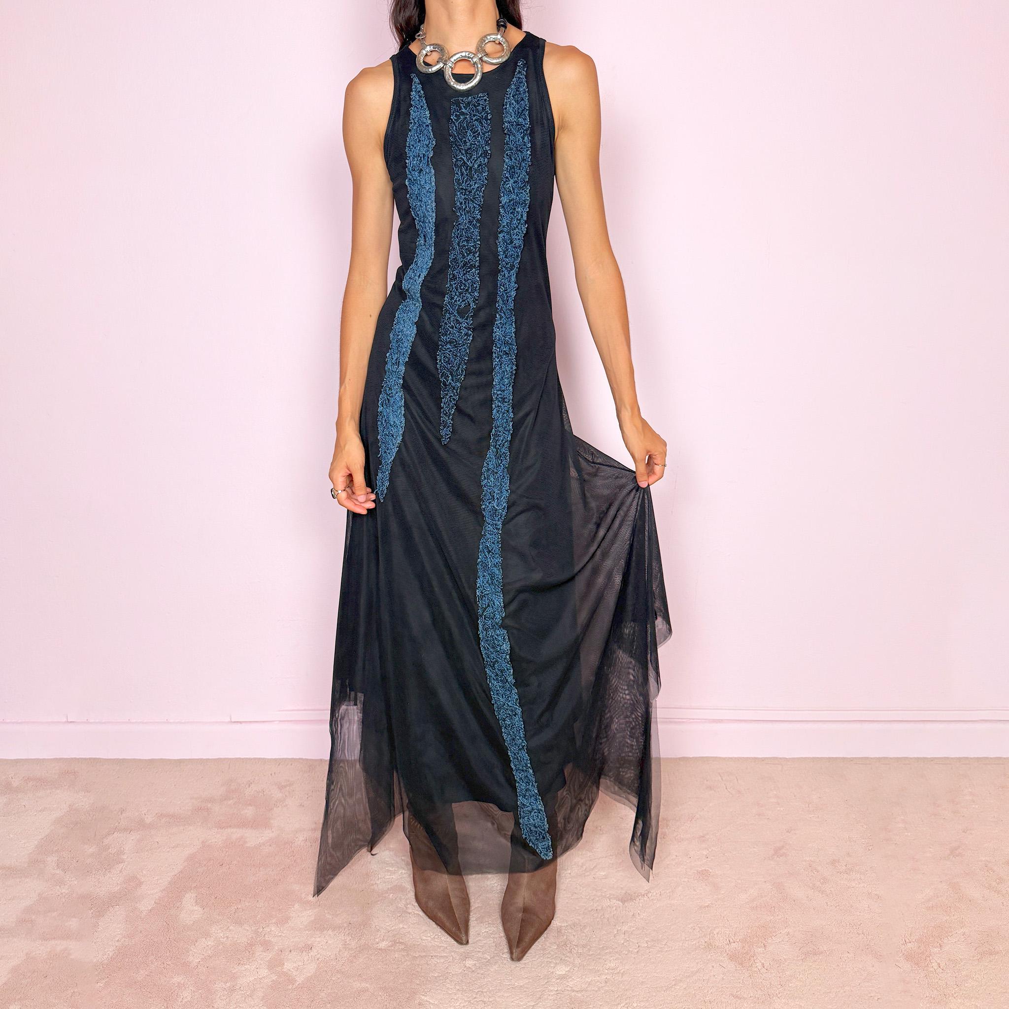 Vintage 2000s maxi dress crafted from stretchy black mesh with a fitted sleeveless silhouette, a semi-sheer outer layer, and an asymmetric flowing hem. Detailed with contrasting blue embroidered threadwork running vertically across the body, creating a textured effect with a distinctly avant-garde Y2K feel. Made in Italy by an Italian brand from 100% polyamide. Excellent vintage condition.