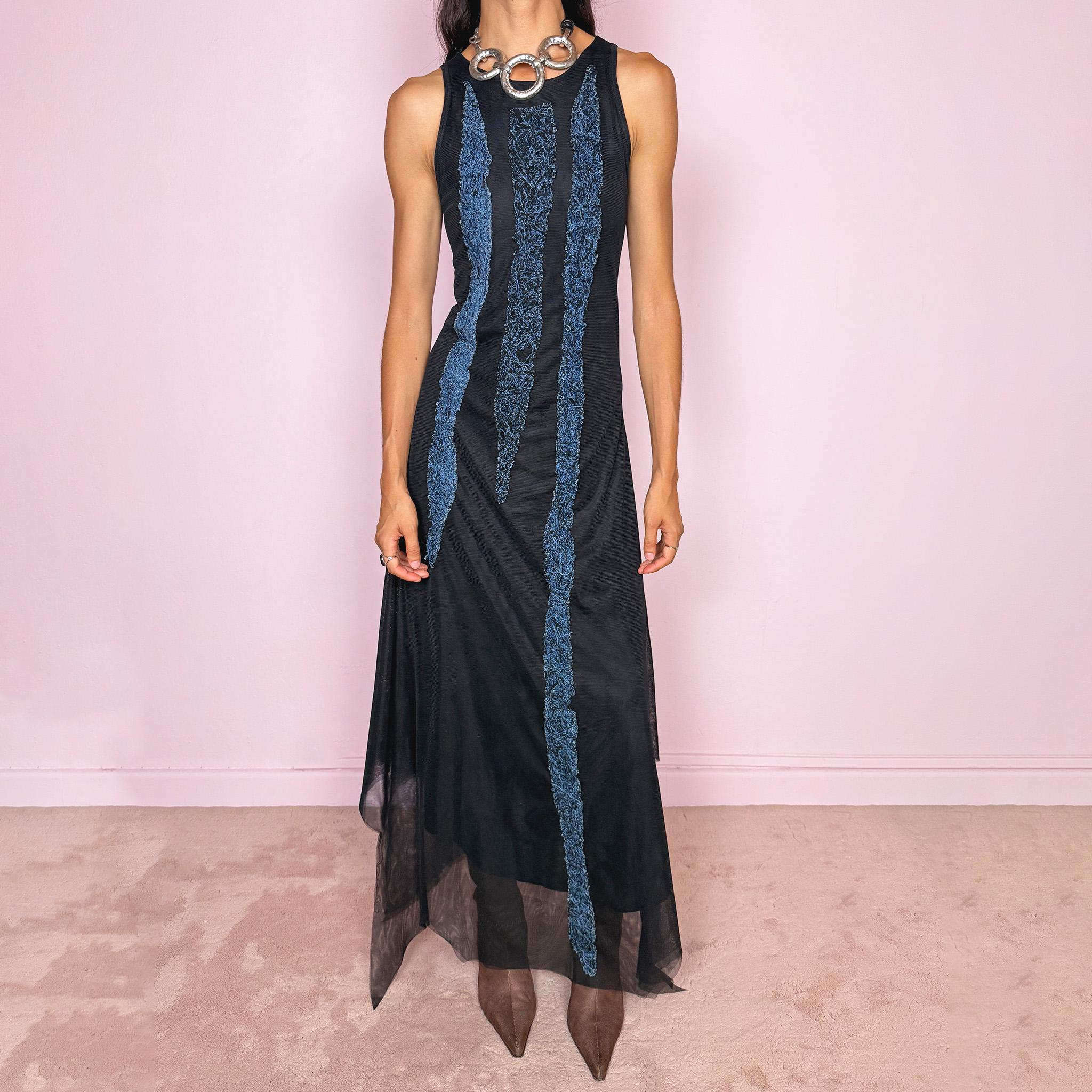 Vintage 2000s maxi dress crafted from stretchy black mesh with a fitted sleeveless silhouette, a semi-sheer outer layer, and an asymmetric flowing hem. Detailed with contrasting blue embroidered threadwork running vertically across the body, creating a textured effect with a distinctly avant-garde Y2K feel. Made in Italy by an Italian brand from 100% polyamide. Excellent vintage condition.