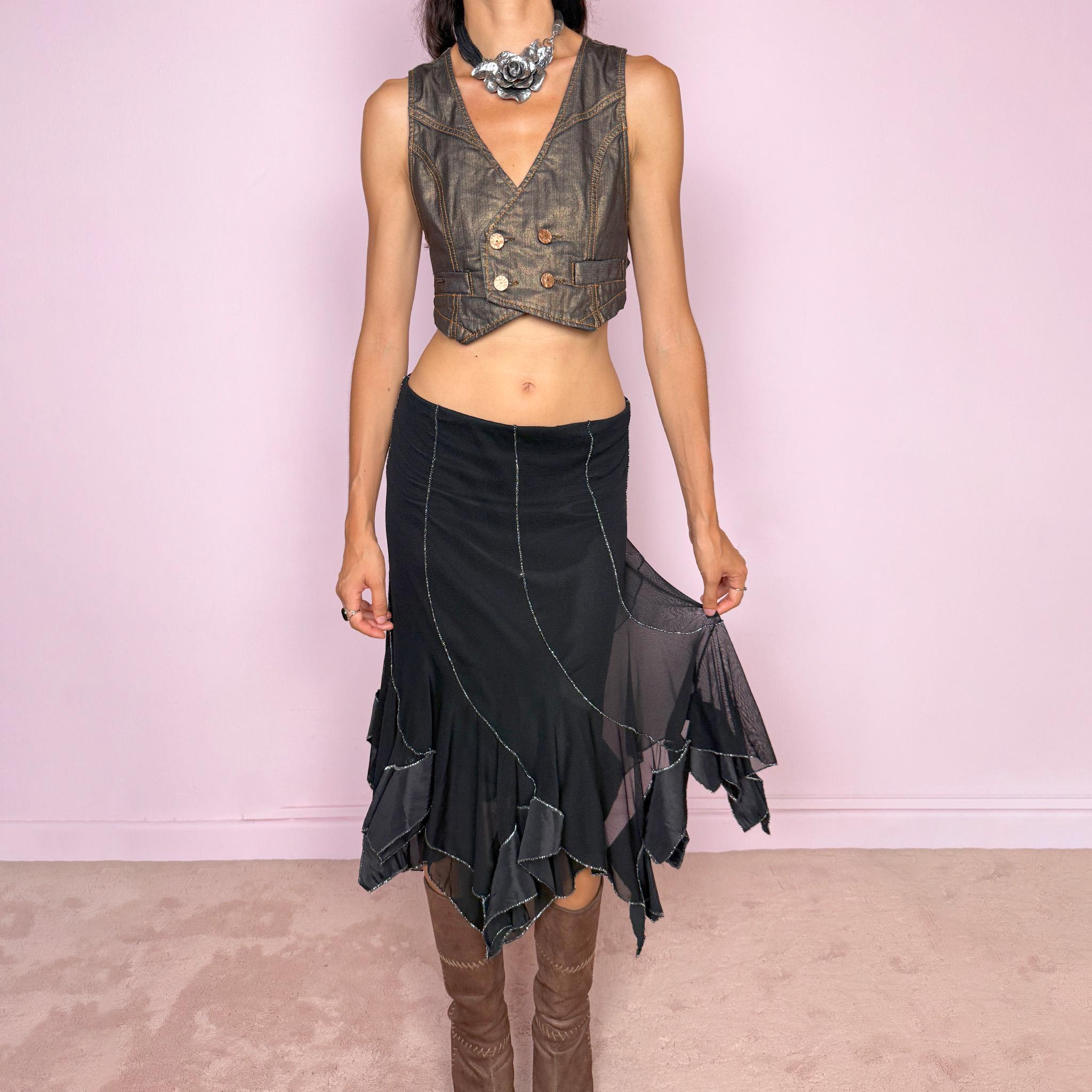 Vintage 2000s black mesh midi skirt, featuring a fluid asymmetric layered construction with sheer panels and an irregular handkerchief hem. Finished with contrasting metallic thread along the curved seams and edges, creating a subtle shimmering effect throughout. Stretchy with an elasticated waist, ideal for statement evening looks. Can be worn mid- to low-rise for size S. Made in Italy from 95% viscose. Excellent vintage condition.