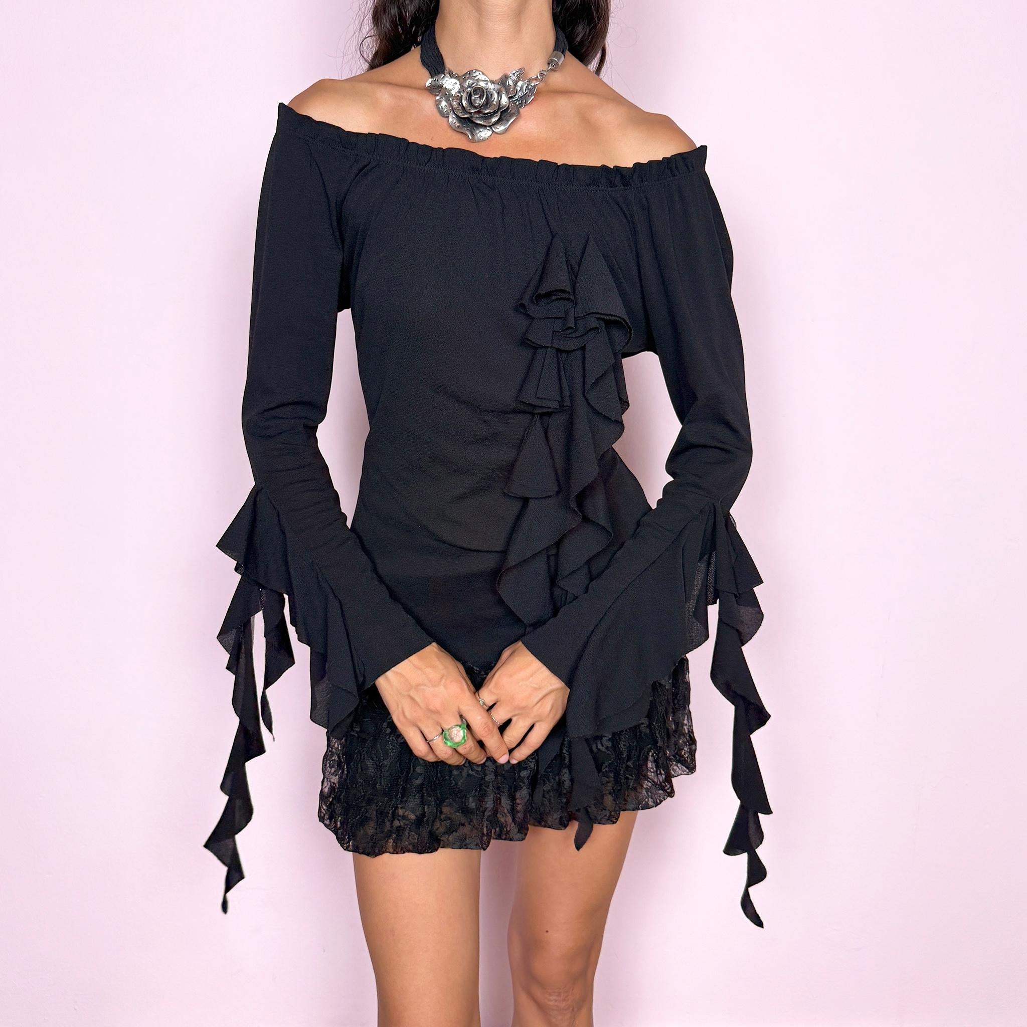 Vintage 2000s black top featuring an off-the-shoulder neckline, fitted silhouette, dramatic cascading front ruffles and flared ruffle cuffs, creating an asymmetric sculptural effect with an experimental avant-garde feel. Made in France by a French brand from stretchy 100% polyamide. Excellent vintage condition.