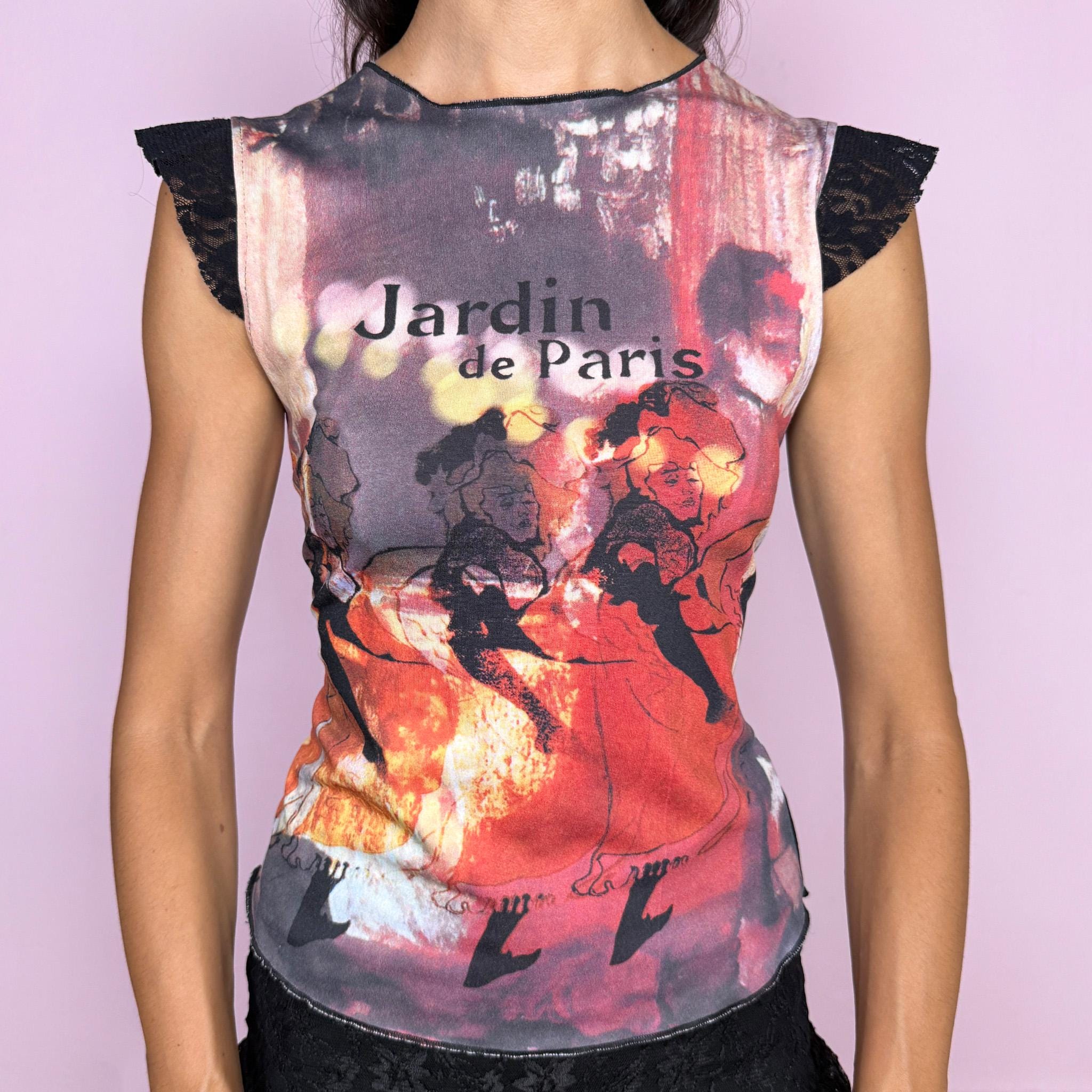 Vintage 2000s fitted graphic top featuring a striking Paris-inspired art print in red, burgundy, black, and warm orange tones. Designed with a feminine “Jardin de Paris” graphic combining illustrated figures and atmospheric photographic imagery, and finished with delicate black lace cap-sleeve inserts. Made from a stretchy polyester, elastane, and nylon blend. A distinctive Y2K art-print piece with a romantic Parisian feel. Excellent vintage condition.