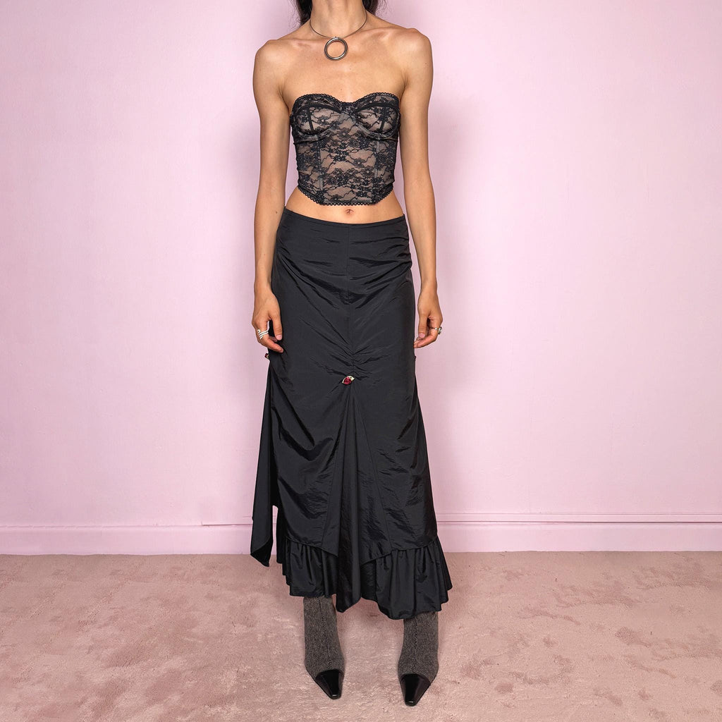 Vintage 2000s black layered ruched midi skirt with a dark gothic avant-garde feel. Back zip closure, structured non-stretch fabric, gathered front ruching, asymmetric layered paneling, ruffled hem, and small floral details. Can be worn high waisted for M or lower rise for S and XS. Made from 100% polyamide with lining 100% polyester. Excellent vintage condition.