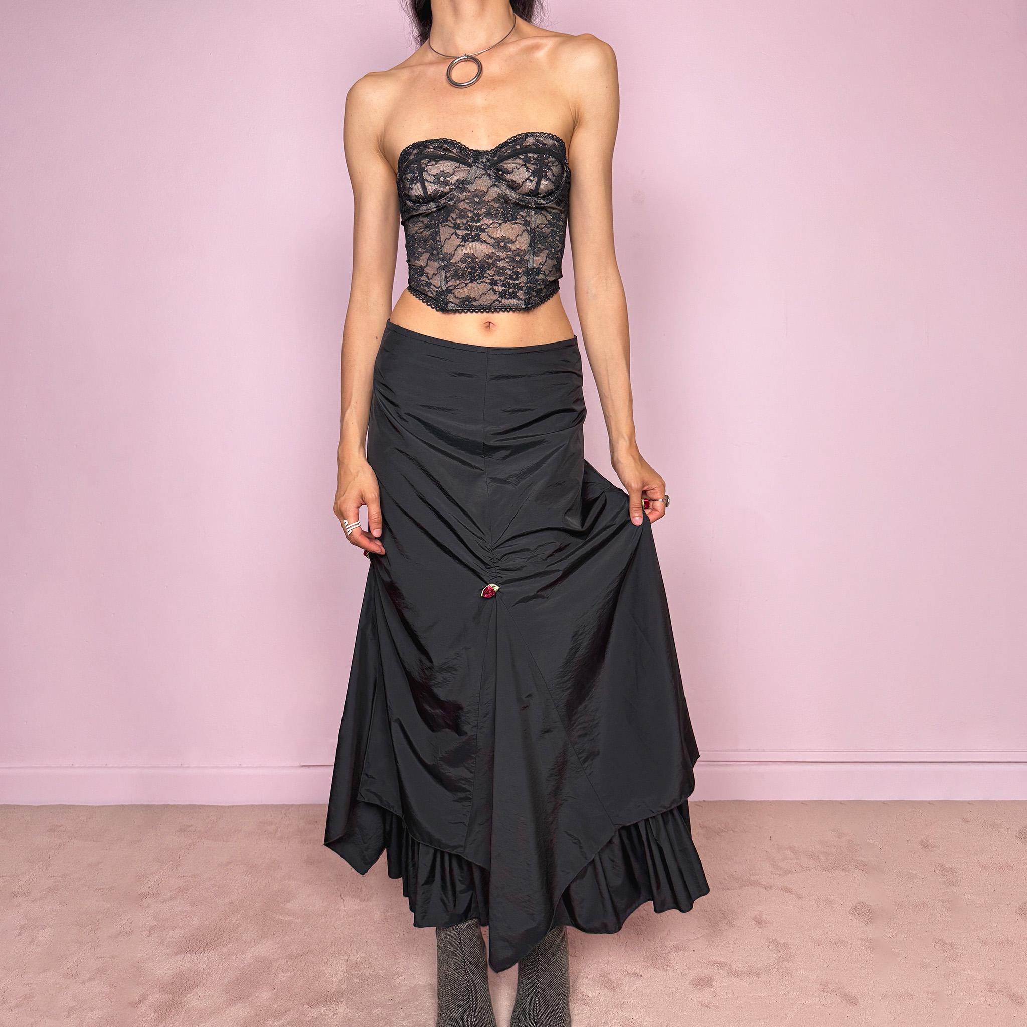 Vintage 2000s black layered ruched midi skirt with a dark gothic avant-garde feel. Back zip closure, structured non-stretch fabric, gathered front ruching, asymmetric layered paneling, ruffled hem, and small floral details. Can be worn high waisted for M or lower rise for S and XS. Made from 100% polyamide with lining 100% polyester. Excellent vintage condition.