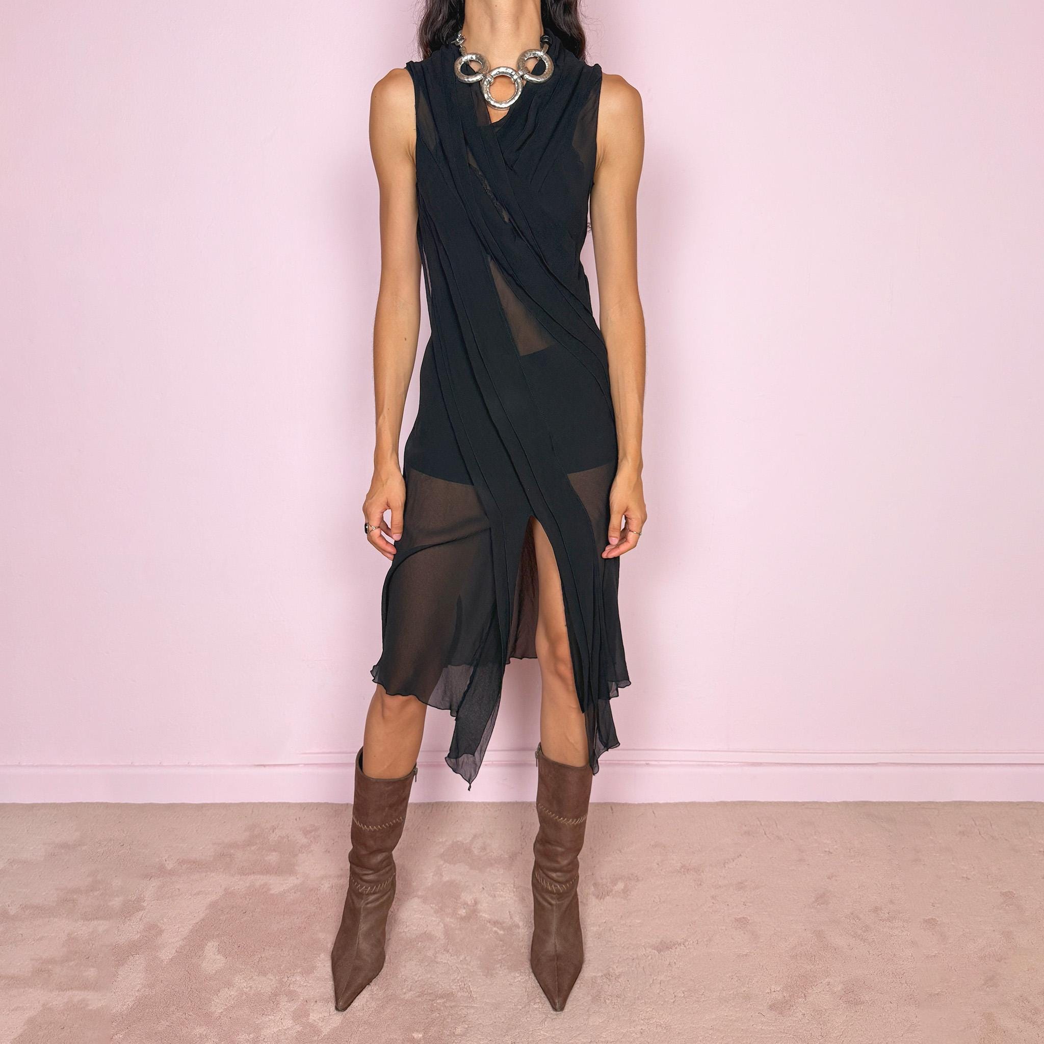 Vintage 2000s black semi-sheer midi dress with a fluid sleeveless silhouette, asymmetric draped panel construction, and a front opening that creates soft movement through the hem. The layered fabric falls in long sculptural lines across the body, giving the dress an elegant dark avant-garde feel. Brand, size, and composition labels are missing; the fabric feels like silk, but the exact composition cannot be confirmed. Great vintage condition.