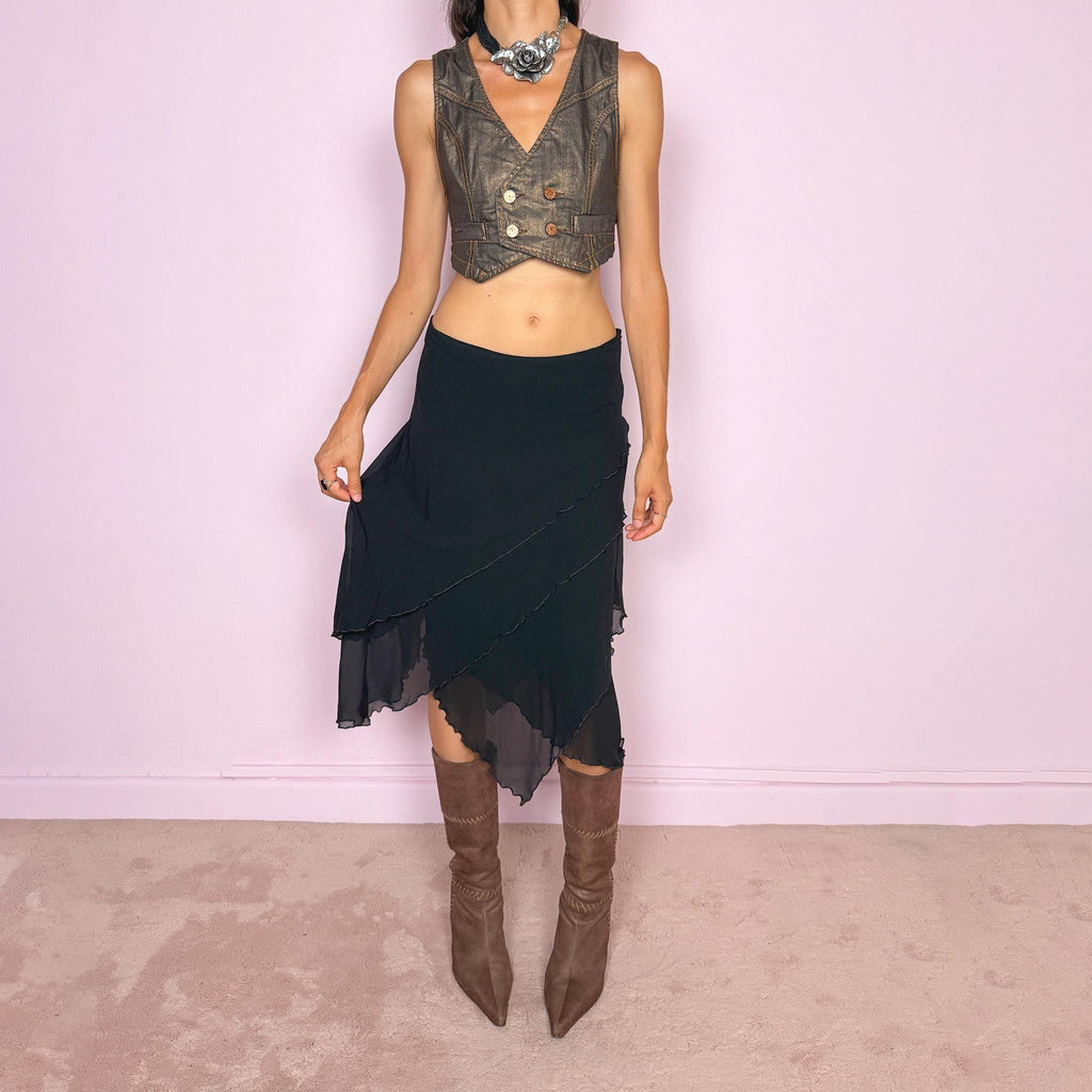 Vintage 2000s black asymmetric midi skirt crafted from 100% silk, featuring a layered construction with overlapping diagonal panels and delicate lettuce-edge finishing throughout. Features a side zip closure and no stretch. An elegant, dark minimalist avant-garde silhouette with beautiful fluid movement. Can be worn mid-rise for size M or lower-rise for size S. By German fashion brand Marc Cain. 100% silk outer with 100% nylon lining. Excellent vintage condition.