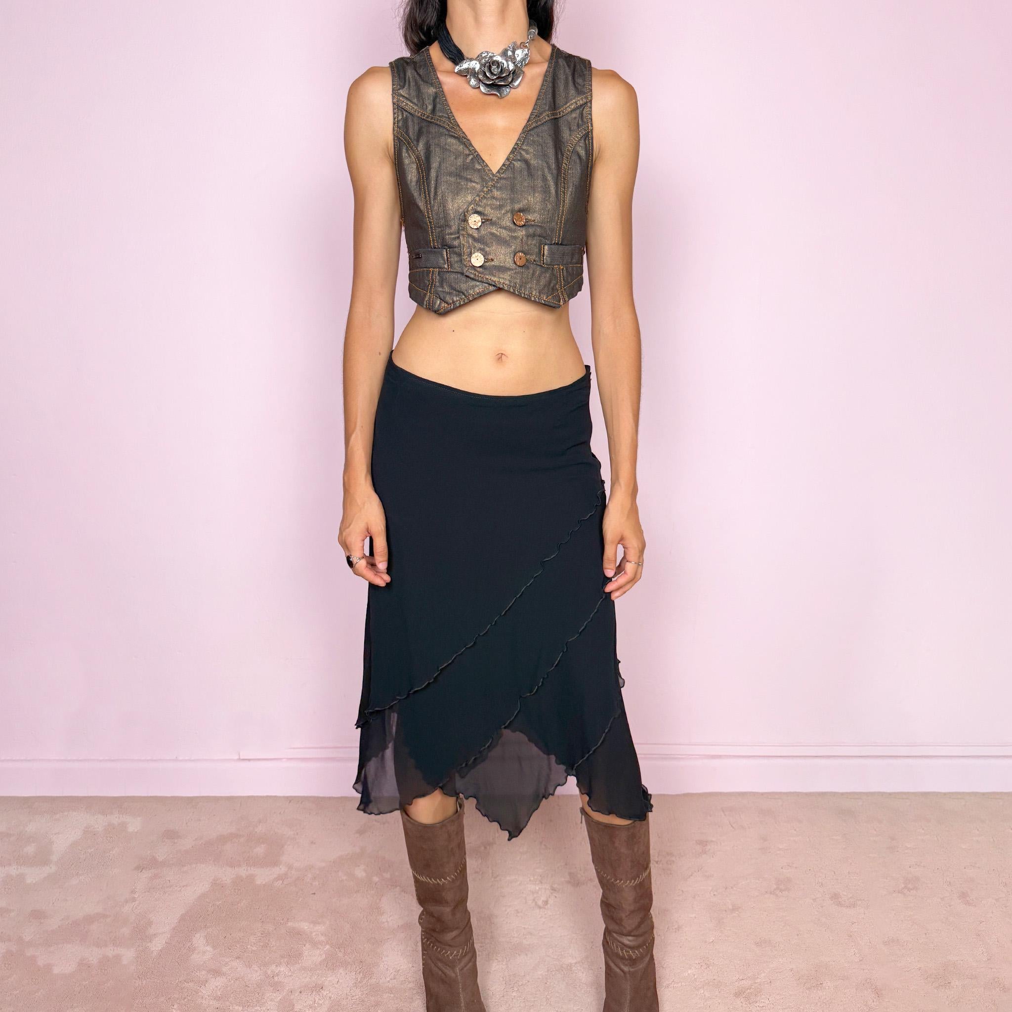 Vintage 2000s black asymmetric midi skirt crafted from 100% silk, featuring a layered construction with overlapping diagonal panels and delicate lettuce-edge finishing throughout. Features a side zip closure and no stretch. An elegant, dark minimalist avant-garde silhouette with beautiful fluid movement. Can be worn mid-rise for size M or lower-rise for size S. By German fashion brand Marc Cain. 100% silk outer with 100% nylon lining. Excellent vintage condition.