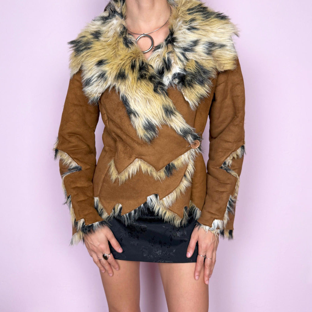 Bold statement vintage 2000s Penny Lane jacket with a brown faux suede exterior and beige and black faux fur interior and collar with an animal print–inspired look. Eye-catching unique design with a fitted silhouette, two-button closure, pockets, and an asymmetric hem. Made from polyester by a European brand. Excellent vintage condition.
