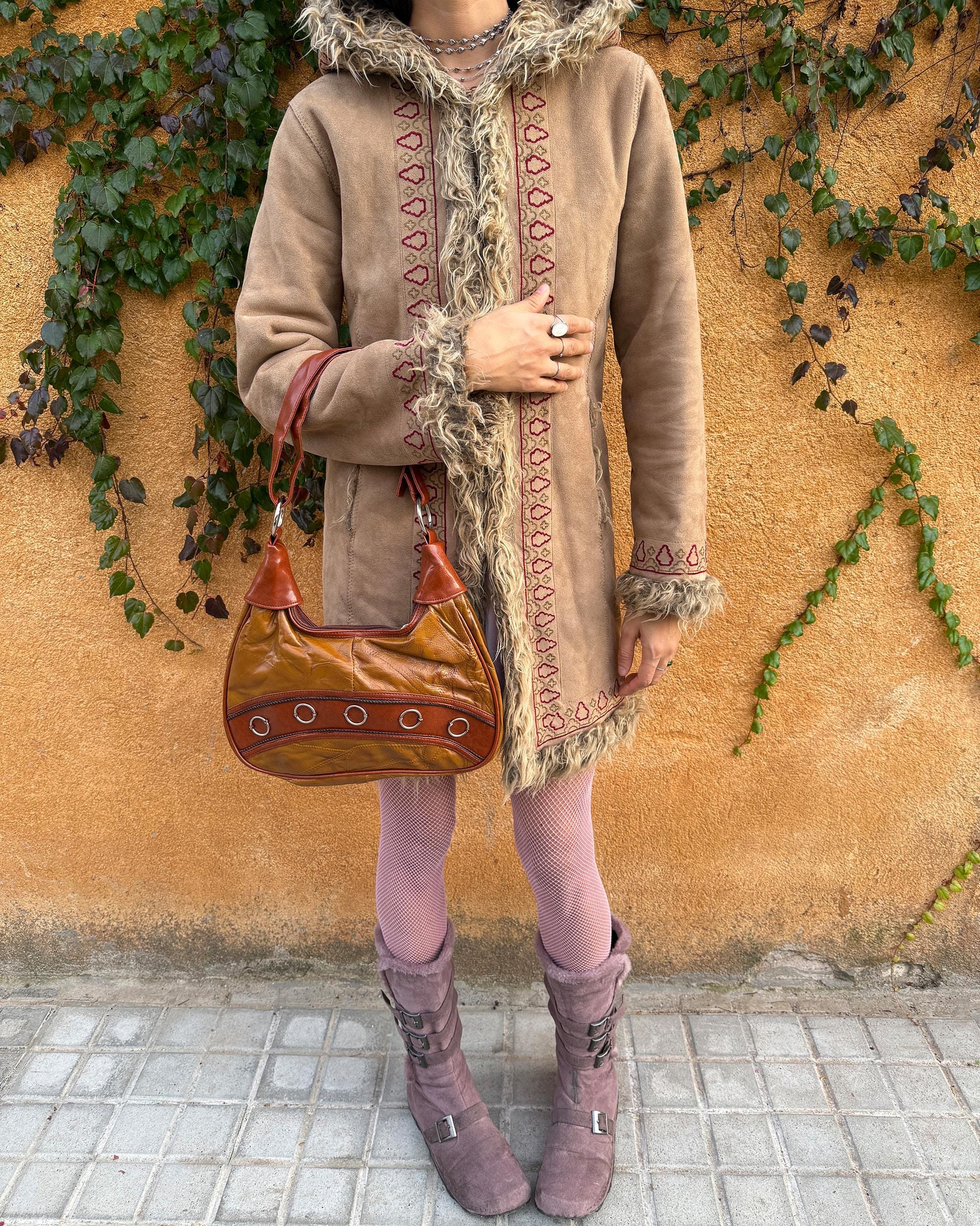 Vintage 2000s brown and mustard-brown faux leather shoulder bag with classic Y2K city-girl appeal. Features metal O-ring details across the front, contrast paneling, and a secure double zip closure. The slouchy silhouette makes it perfect as a bold 2000s statement everyday bag or a party-night accessory. Excellent vintage condition.