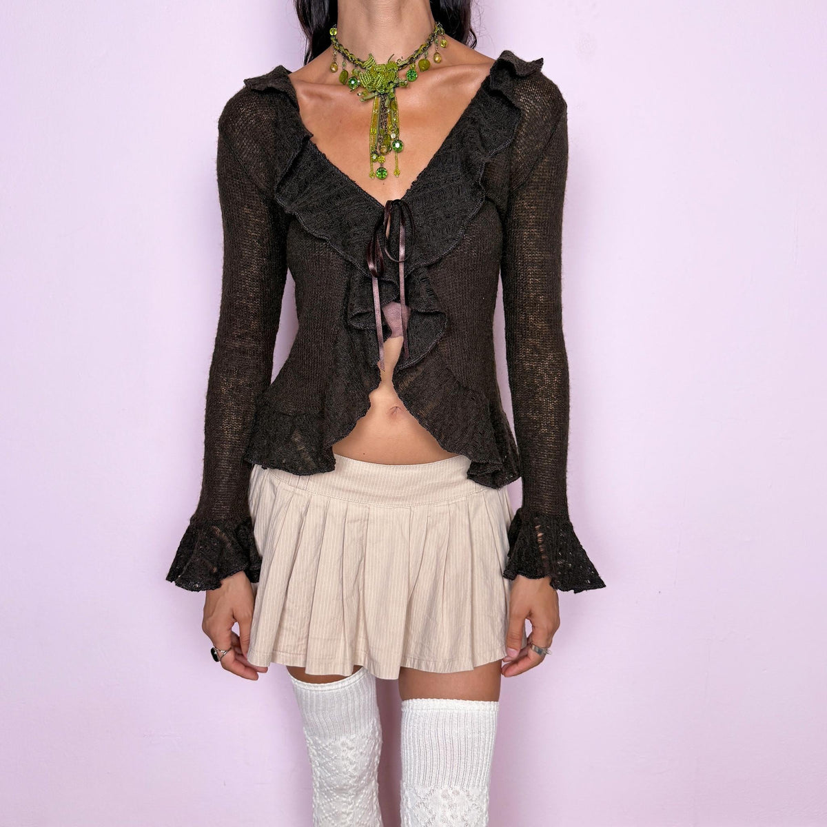 Vintage 2000s dark brown tie-front cardigan, made in Italy from a lightweight, stretchy blend of 35% mohair, 40% polyamide, 20% acrylic, and 5% elastane. Featuring a fitted, open-front silhouette with an adjustable tie fastening, cascading ruffle detailing along the neckline and front, long sleeves, and flared ruffle cuffs. The semi-sheer, airy knit and rich chocolate-brown tone give it a dreamy, romantic aesthetic. Excellent vintage condition.
