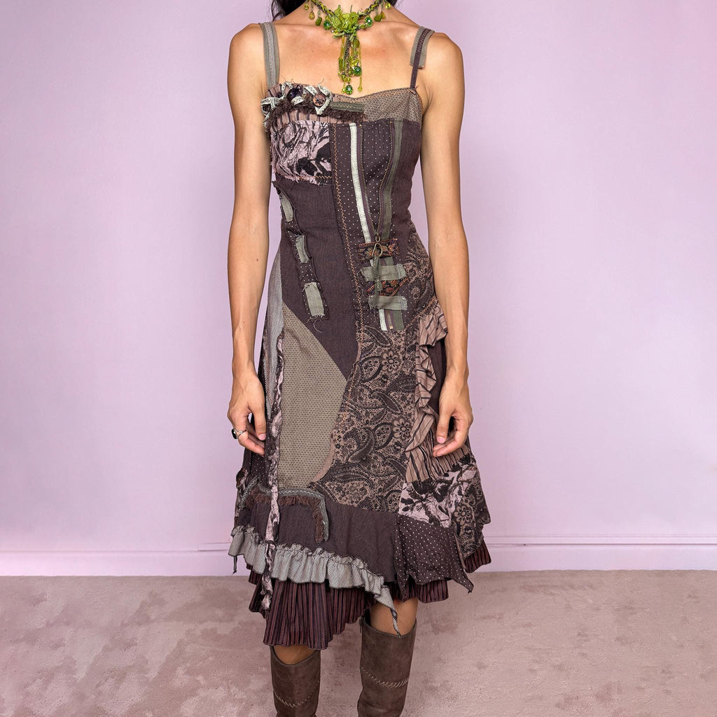 Vintage 2000s deconstructed midi dress with a distinctive rag-doll-inspired patchwork construction in brown, khaki green, mauve, and gray tones. Featuring mixed patterned panels, exposed raw-edge seams, contrast stitching, ribbon and buckle details, gathered ruffles, and an irregular layered hem for a highly textured avant-garde silhouette. Designed with adjustable shoulder straps, a shirred elastic back for flexibility, and a side zip closure.