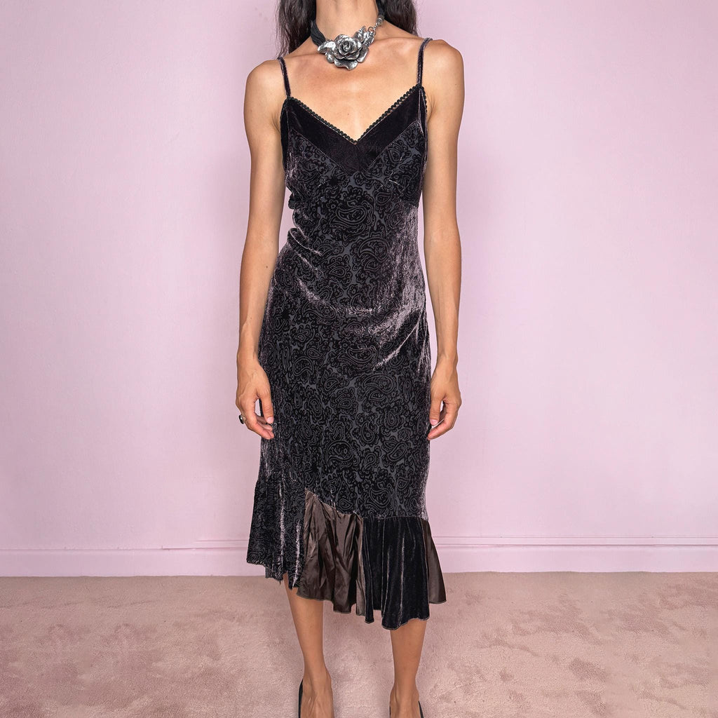 Vintage 2000s brown velvet devoré slip midi dress with burnout paisley texture, adjustable straps, V neckline, fluid drape, and asymmetric ruffled hem. Subtle sheen gives it an elegant dark romantic feel, ideal for mysterious night rendezvous. Made in France from 70% viscose and 30% silk blend. Excellent vintage condition.