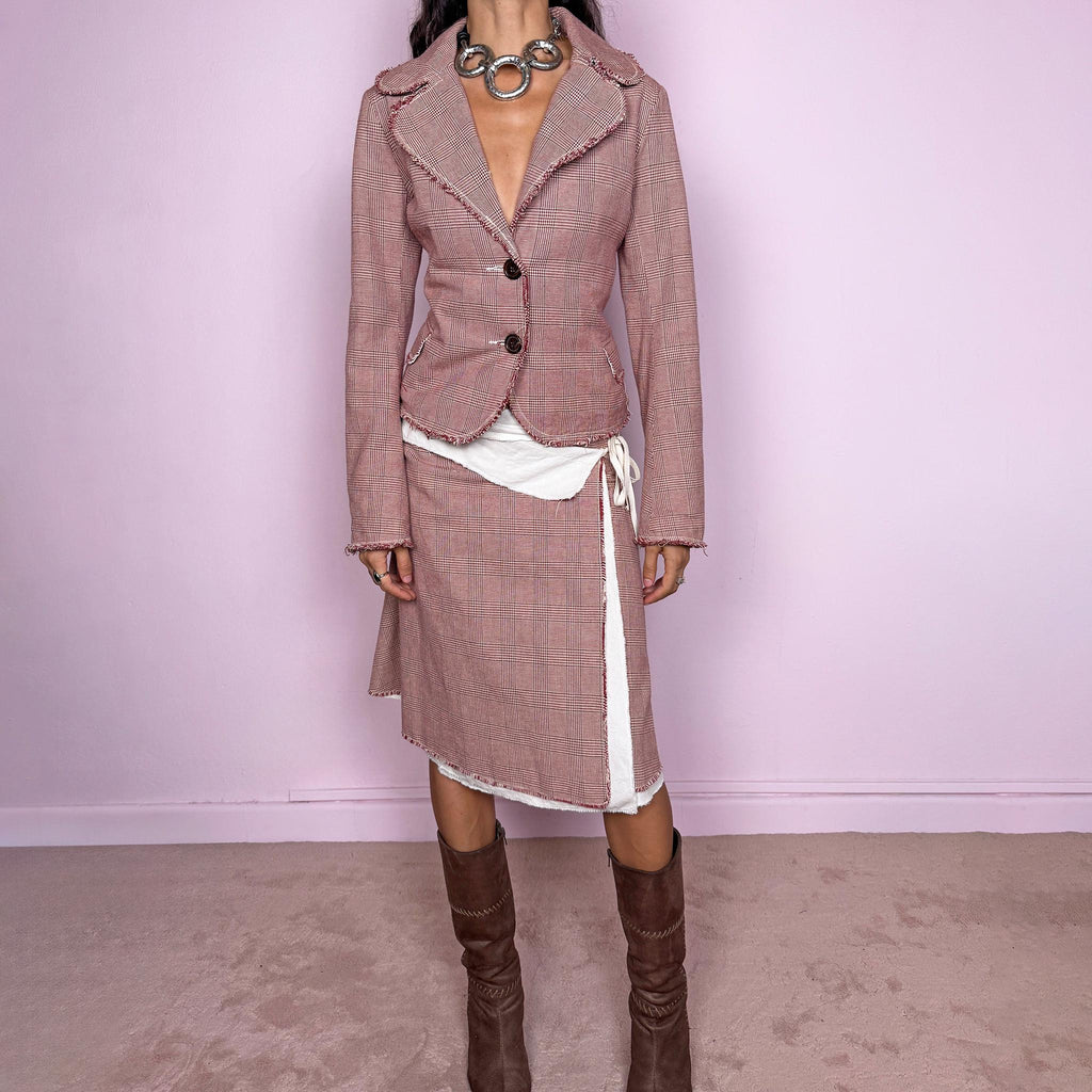 Vintage 2000s burgundy-red and cream two-piece skirt suit. The set includes a fitted blazer with a glen plaid / Prince of Wales check pattern, raw-edge trim, notched lapels, and a two-button front closure. Paired with a matching wrap-style midi skirt featuring layered cream lining, a side button closure, and an adjustable tie. The contrasting construction and unfinished edges create a relaxed, deconstructed feel while maintaining a tailored silhouette.