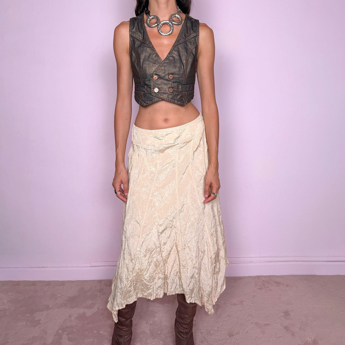 Vintage 2000s light cream-gold asymmetric midi skirt featuring a flared silhouette with an irregular handkerchief-style hem and a subtly crinkled, textured finish. Crafted from a structured, non-stretch blend of 53% polyamide, 32% cotton and 15% metallic fiber, with a 65% acetate and 35% viscose lining. Finished with a side zip closure. Can be worn mid-rise for size S or lower on the waist for size XS. From a German brand. Excellent vintage condition.