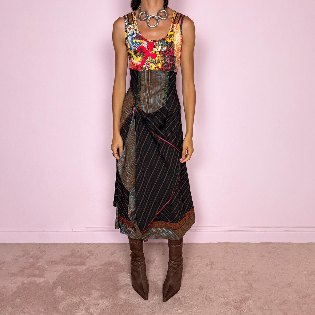 Vintage 2000s midi dress designed with a dramatic medieval-inspired avant-garde silhouette. It features a graphic bust panel with vivid abstract artwork, a fitted corset-effect waist with striped and patterned panels, a side zip closure, and a flowing asymmetric skirt with mixed striped fabrics, contrast trims, and layered draped sections for sculptural movement. Only the bust area has stretch, while the rest of the dress  A rare fantasy statement piece with a theatrical baroque feel.