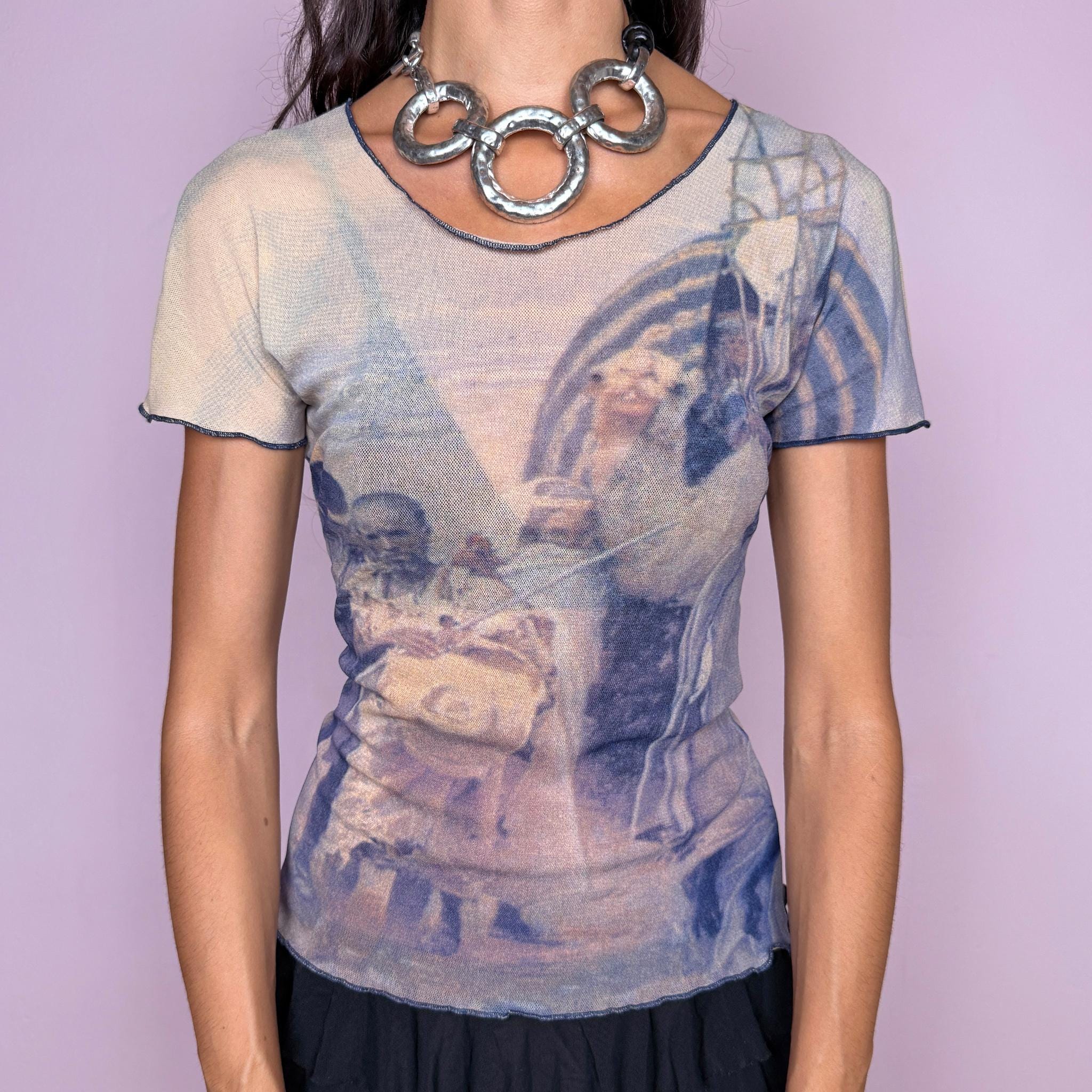 Vintage 2000s semi-sheer mesh top featuring an artistic photographic-style graphic print in muted beige and navy blue tones, with a fitted second-skin silhouette and short sleeves. The design has an art-to-wear feel with understated avant-garde appeal, perfect for bold, ethereal outfits. Designed by Finnish designer Ritva Falla for Marimekko and made in Finland from stretchy 100% polyamide. Excellent vintage condition.