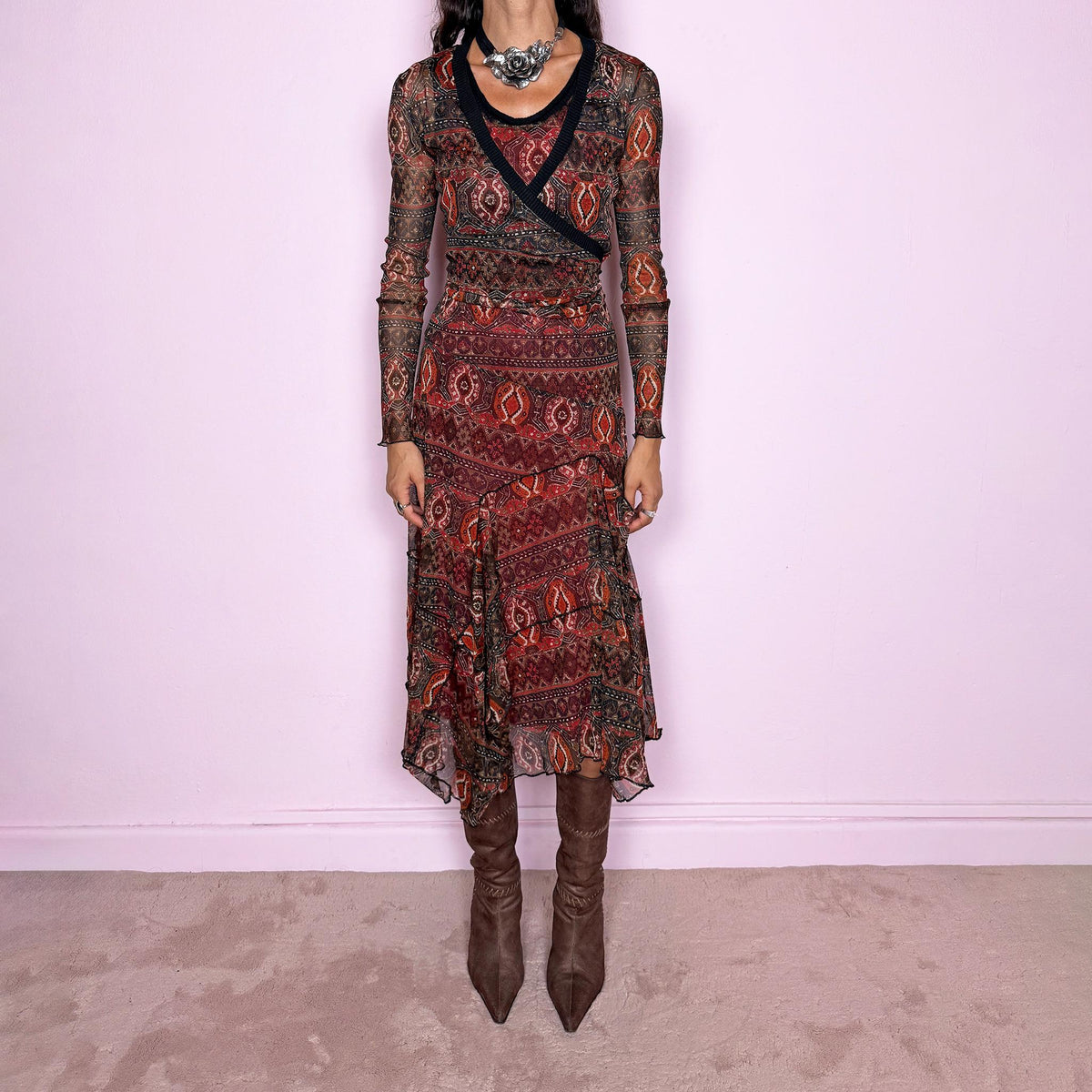 Vintage 2000s printed mesh two-piece dress set. The set includes a fitted sleeveless midi dress with a red lining and asymmetric layered hem, paired with a long-sleeve sheer mesh wrap top with tie fastening and contrasting black trim. Finished in an earthy red, burgundy, brown, and orange graphic print throughout. Perfect for layered bohemian styling. From a French brand, made in France from stretchy 100% polyester. Great vintage condition.