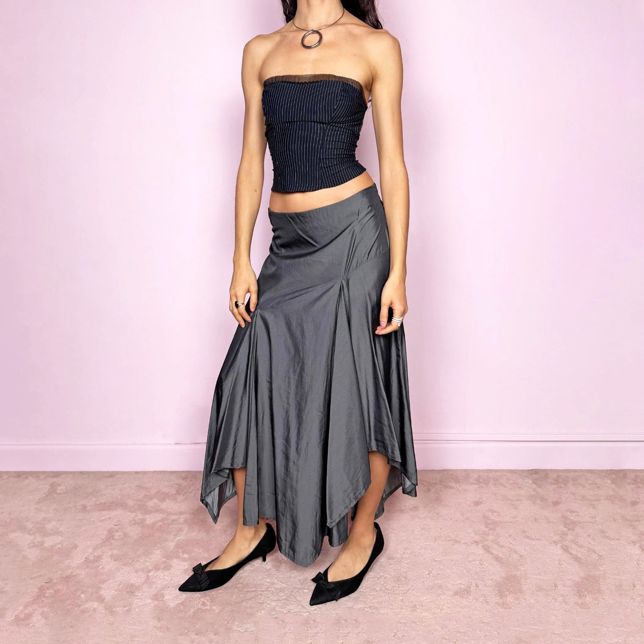 Vintage 2000s silver gray midi skirt with an avant garde asymmetric deconstructed design and fluid godet panel details. Features a glossy satin-like finish, no stretch structure, and back zip closure. Can be worn low rise for size S or mid rise for size M. Perfect for formal, statement, or evening wear. Made from a polyester viscose blend. Excellent vintage condition.