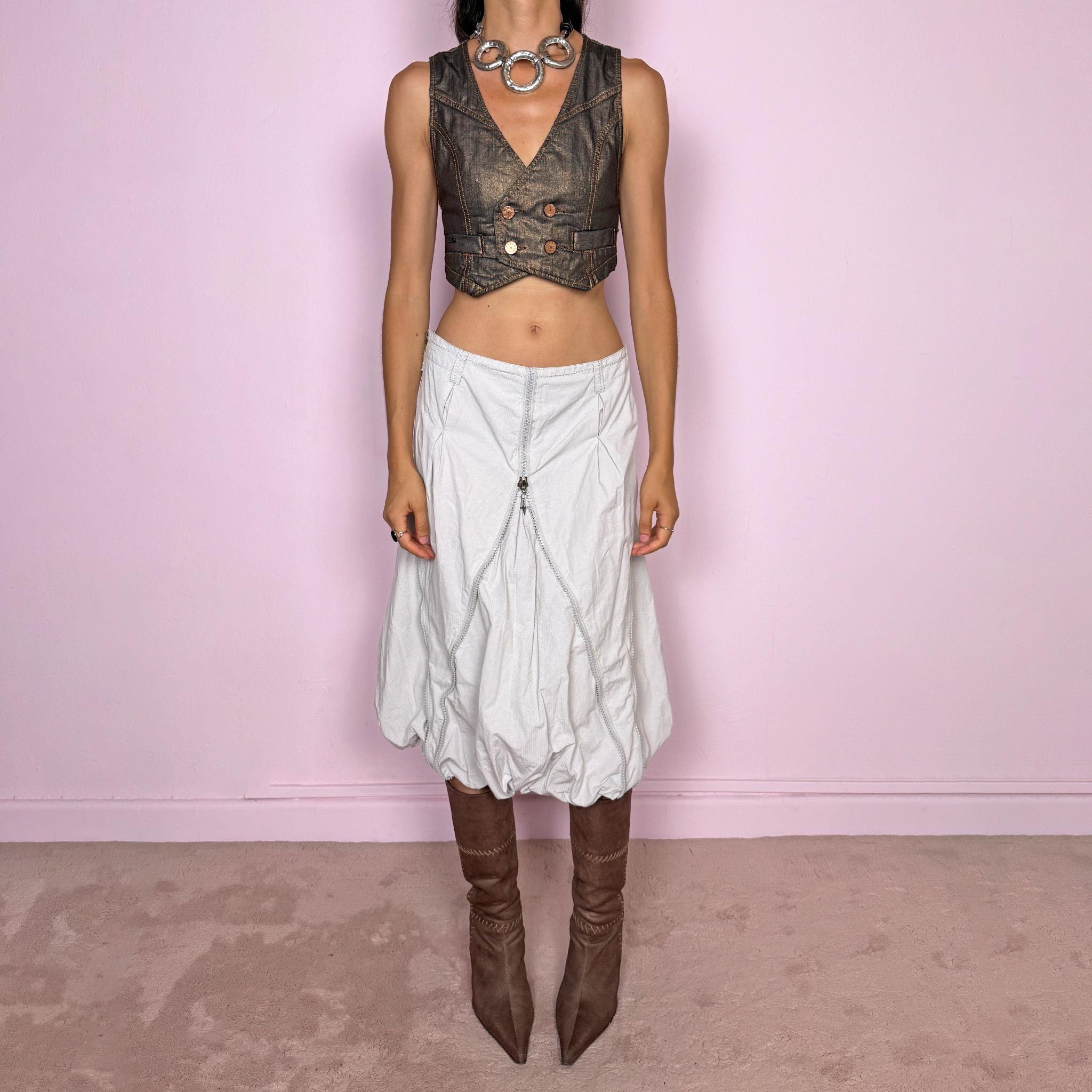 Vintage 2000s light gray midi skirt featuring a voluminous bubble silhouette with sculptural panel construction, curved seam detailing, and exposed silver-tone zippers that create a distinctive deconstructed, utility, avant-garde, futuristic look. Can be worn mid- to high-waisted for size L or lower on the waist for size M. Made by a Danish brand from a 60% cotton and 40% polyester blend with no stretch and finished with a side zip closure. Excellent vintage condition.