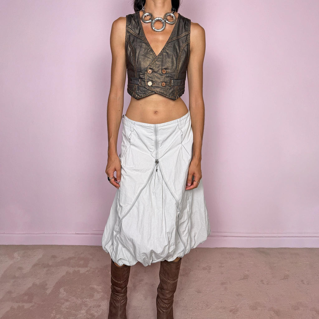 Vintage 2000s light gray midi skirt featuring a voluminous bubble silhouette with sculptural panel construction, curved seam detailing, and exposed silver-tone zippers that create a distinctive deconstructed, utility, avant-garde, futuristic look. Can be worn mid- to high-waisted for size L or lower on the waist for size M. Made by a Danish brand from a 60% cotton and 40% polyester blend with no stretch and finished with a side zip closure. Excellent vintage condition.