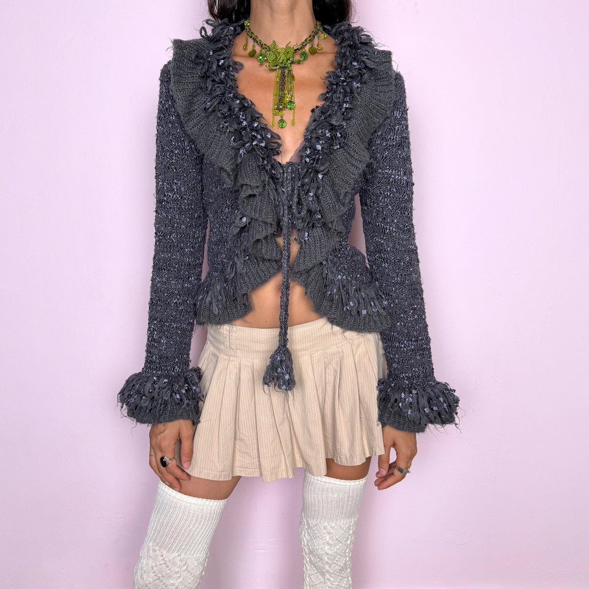 Vintage 2000s romantic gray tie-front cardigan crafted from a fuzzy 70% mohair, 20% acrylic, and 10% elastane blend. Featuring an adjustable tie fastening, dramatic textured fringe ruffle detailing along the neckline and hem, and long sleeves finished with ruffle cuffs. The brand label is missing. Excellent vintage condition.