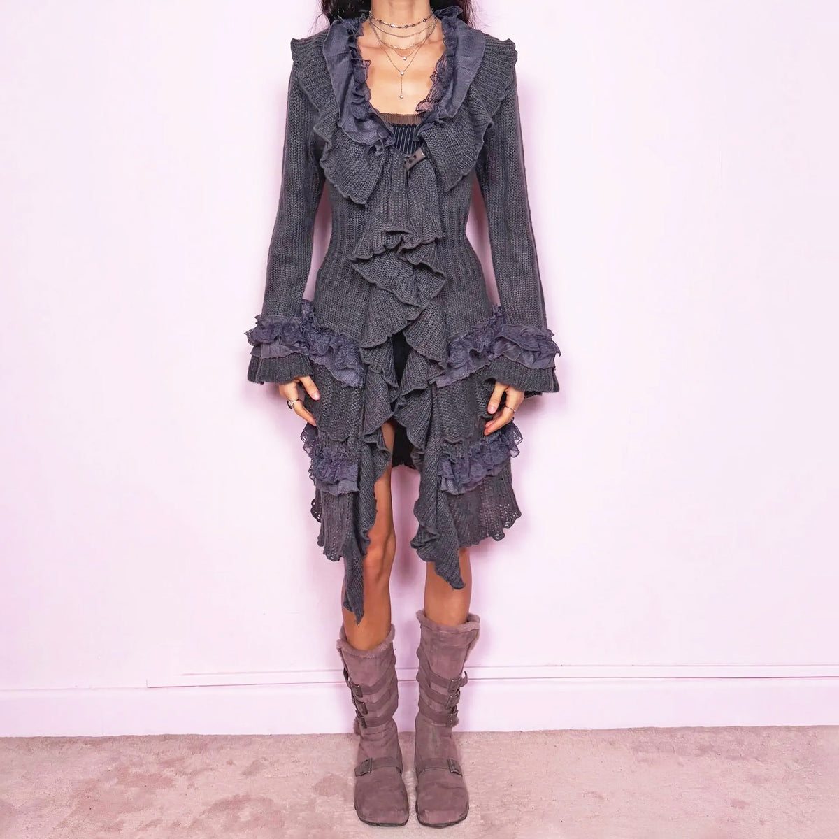 Romantic vintage 2000s dark gray longline cardigan with a dramatic ruffle neckline and lace details. Features bell sleeves with ruffled cuffs, a toggle front closure, and an asymmetric pointed hem. Whimsical fairycore silhouette with a dark baroque rococo style. Made from a stretchy blend of 35% mohair, 20% wool, and 45% acrylic. Excellent vintage condition.