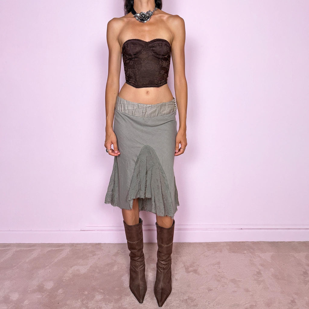 Vintage 2000s khaki green midi skirt, made in Italy and crafted from a lightweight 60% cotton and 40% silk blend. Features an asymmetric hem, delicate semi-sheer godet-style inserts, raw-edged detailing, and round bead-like buttons for an ethereal, fairy-like deconstructed feel. Finished with a side zip closure and no stretch. Can be worn mid- to low-rise for sizes XS–S. From an Italian brand. Excellent vintage condition.