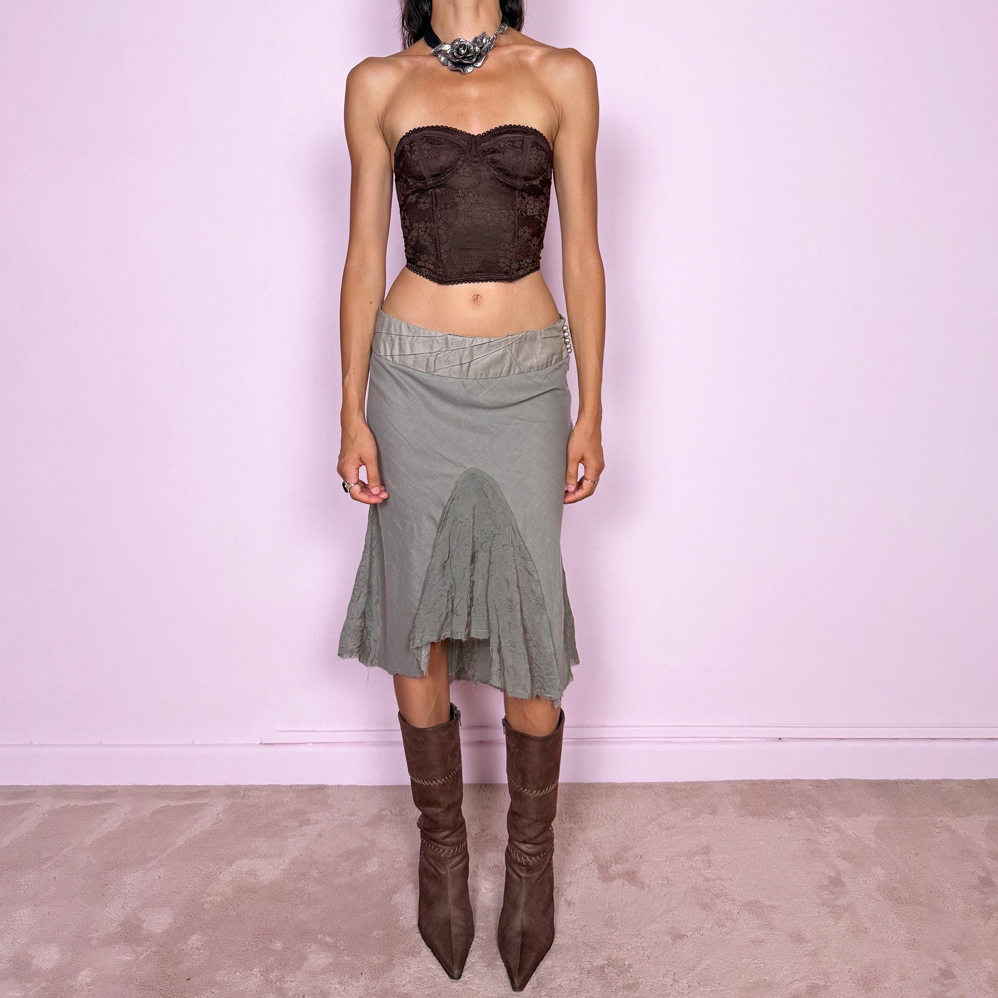 Vintage 2000s khaki green midi skirt, made in Italy and crafted from a lightweight 60% cotton and 40% silk blend. Features an asymmetric hem, delicate semi-sheer godet-style inserts, raw-edged detailing, and round bead-like buttons for an ethereal, fairy-like deconstructed feel. Finished with a side zip closure and no stretch. Can be worn mid- to low-rise for sizes XS–S. From an Italian brand. Excellent vintage condition.