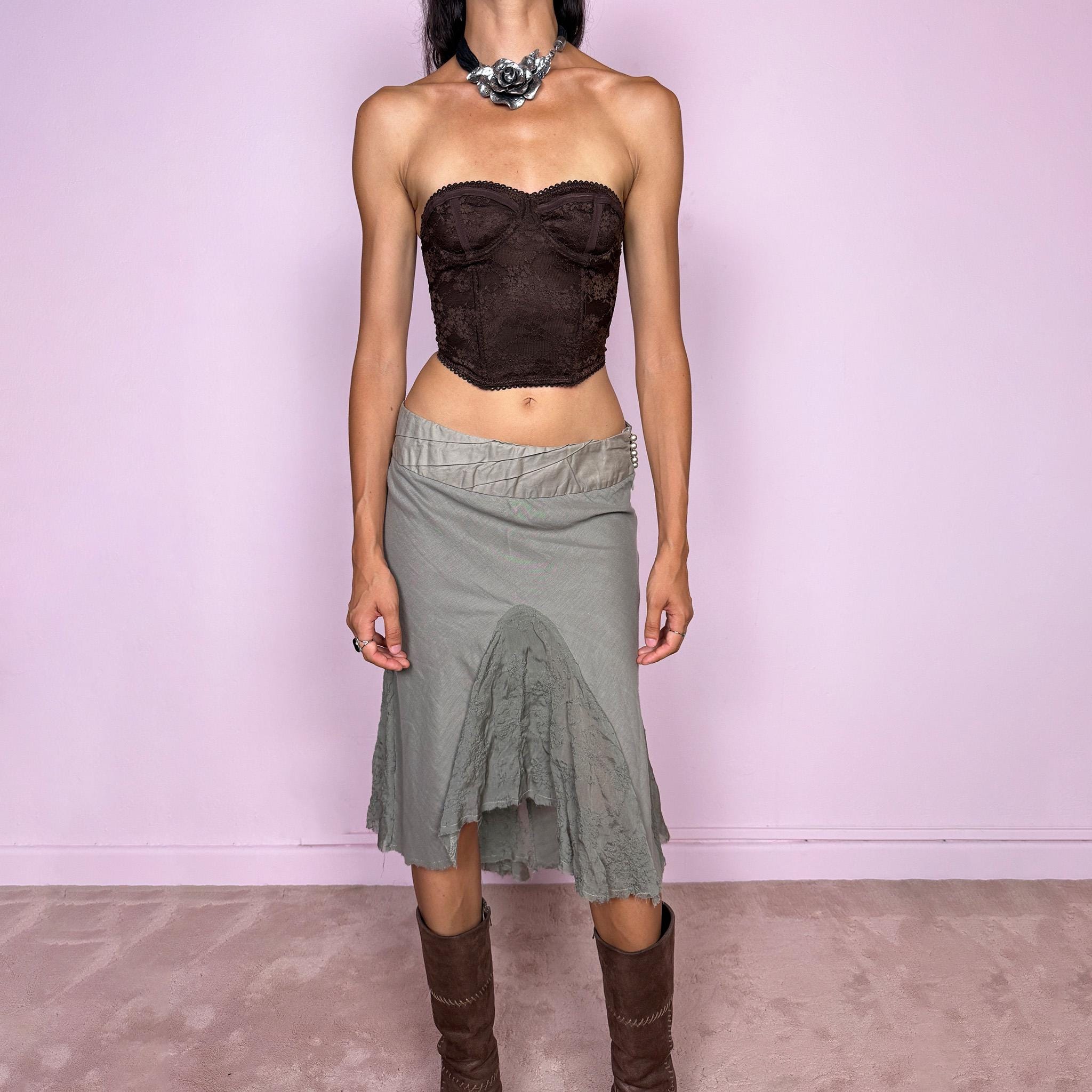 Vintage 2000s khaki green midi skirt, made in Italy and crafted from a lightweight 60% cotton and 40% silk blend. Features an asymmetric hem, delicate semi-sheer godet-style inserts, raw-edged detailing, and round bead-like buttons for an ethereal, fairy-like deconstructed feel. Finished with a side zip closure and no stretch. Can be worn mid- to low-rise for sizes XS–S. From an Italian brand. Excellent vintage condition.