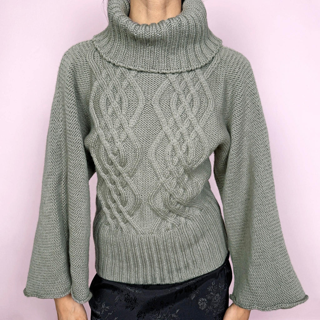 Vintage khaki green grayish 100% pure new wool cable knit sweater featuring a chunky texture, an oversized turtleneck, and wide long sleeves. Crafted from thick, high-quality wool for warmth and a refined feel, making it a standout staple for colder seasons. Made in England. Excellent vintage condition.