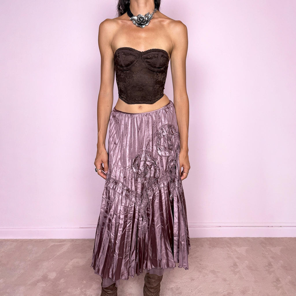 Vintage 2000s dusty mauve metallic midi skirt featuring intricate all-over pleating with a fluid iridescent sheen, sculptural floral appliqué details, and sheer tulle fabric peeking from underneath the hem. Ideal for parties or dreamy, romantic elevated outfits. Can be worn high-waisted for size S or lower on the waist for size XS. From a French brand. Crafted from 100% polyester with no stretch and finished with a side zip closure. Excellent vintage condition.