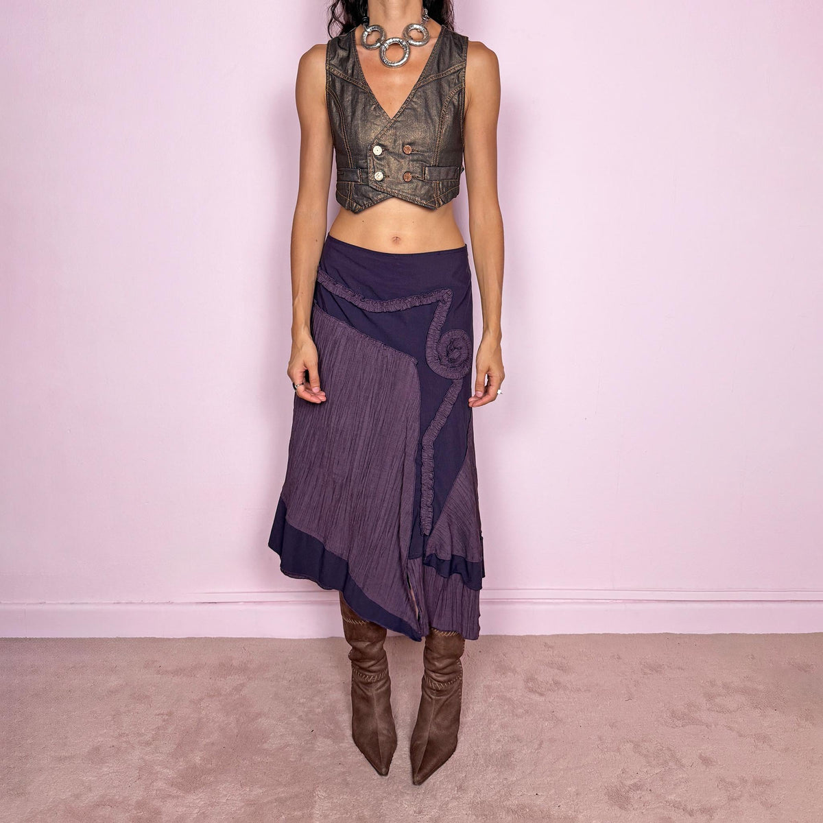 Vintage 2000s dark purple asymmetric midi skirt from a French brand, made in France. Features an irregular layered silhouette with contrasting pleated panels, curved seam construction, sculptural ruffled appliqué detailing, and a layered hem. Finished with a side zip closure. Can be worn high-waisted for size L or lower on the waist for sizes M–S.