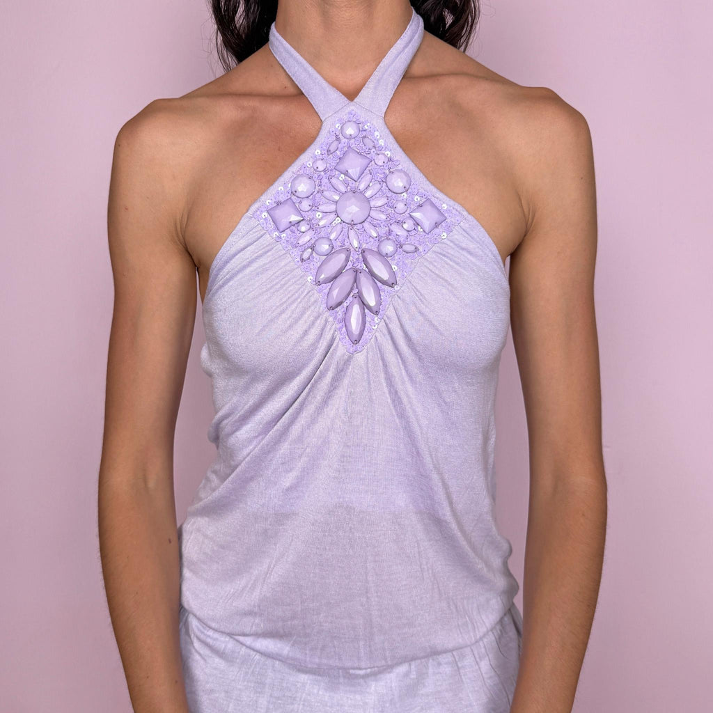 Vintage 2000s lilac halter top in 100% viscose with a tie-neck halter silhouette, soft draped longline fit, gathered bust, and embellished front panel with oversized jewel-like plastic appliqués and subtle sequins. Lightweight with a fluid feel, perfect as a statement summer top with fairy-mermaid Y2K energy. From a French brand. Excellent vintage condition.