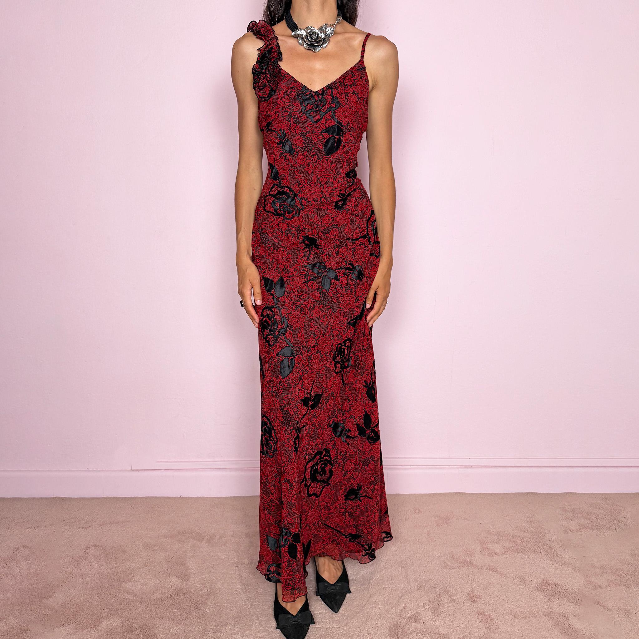 Vintage 2000s red and black floral maxi dress with a fitted silhouette, spaghetti straps, and a dramatic ruffle detail at one shoulder. Designed with a V neckline, long flowing skirt, and black floral motifs over a deep red base, creating a dark romantic evening look. Lightweight with no stretch, a softly semi-sheer outer layer, and black lining, perfect for formal occasions. Composition label is missing, so the exact fabric is unknown. Excellent vintage condition.