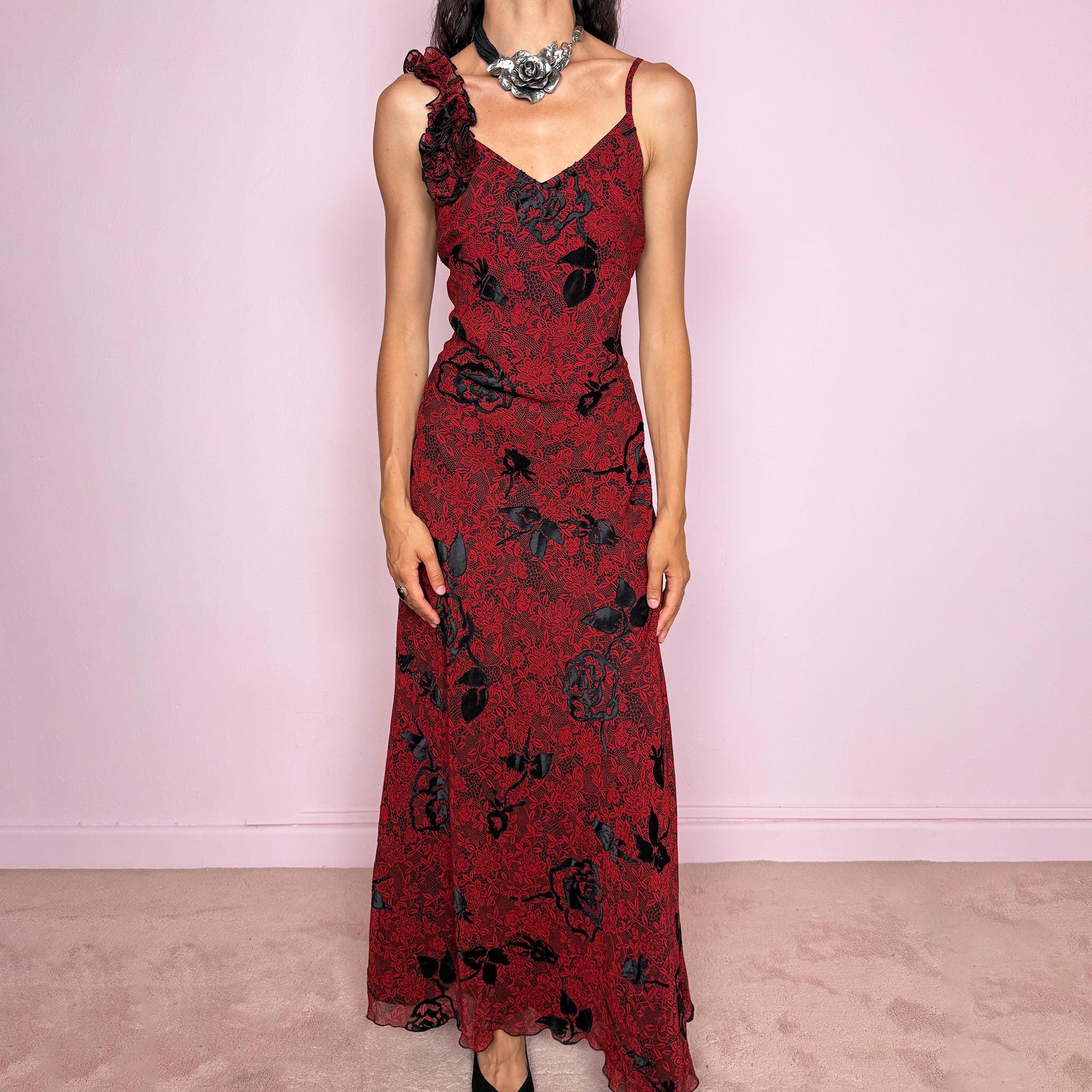Vintage 2000s red and black floral maxi dress with a fitted silhouette, spaghetti straps, and a dramatic ruffle detail at one shoulder. Designed with a V neckline, long flowing skirt, and black floral motifs over a deep red base, creating a dark romantic evening look. Lightweight with no stretch, a softly semi-sheer outer layer, and black lining, perfect for formal occasions. Composition label is missing, so the exact fabric is unknown. Excellent vintage condition.