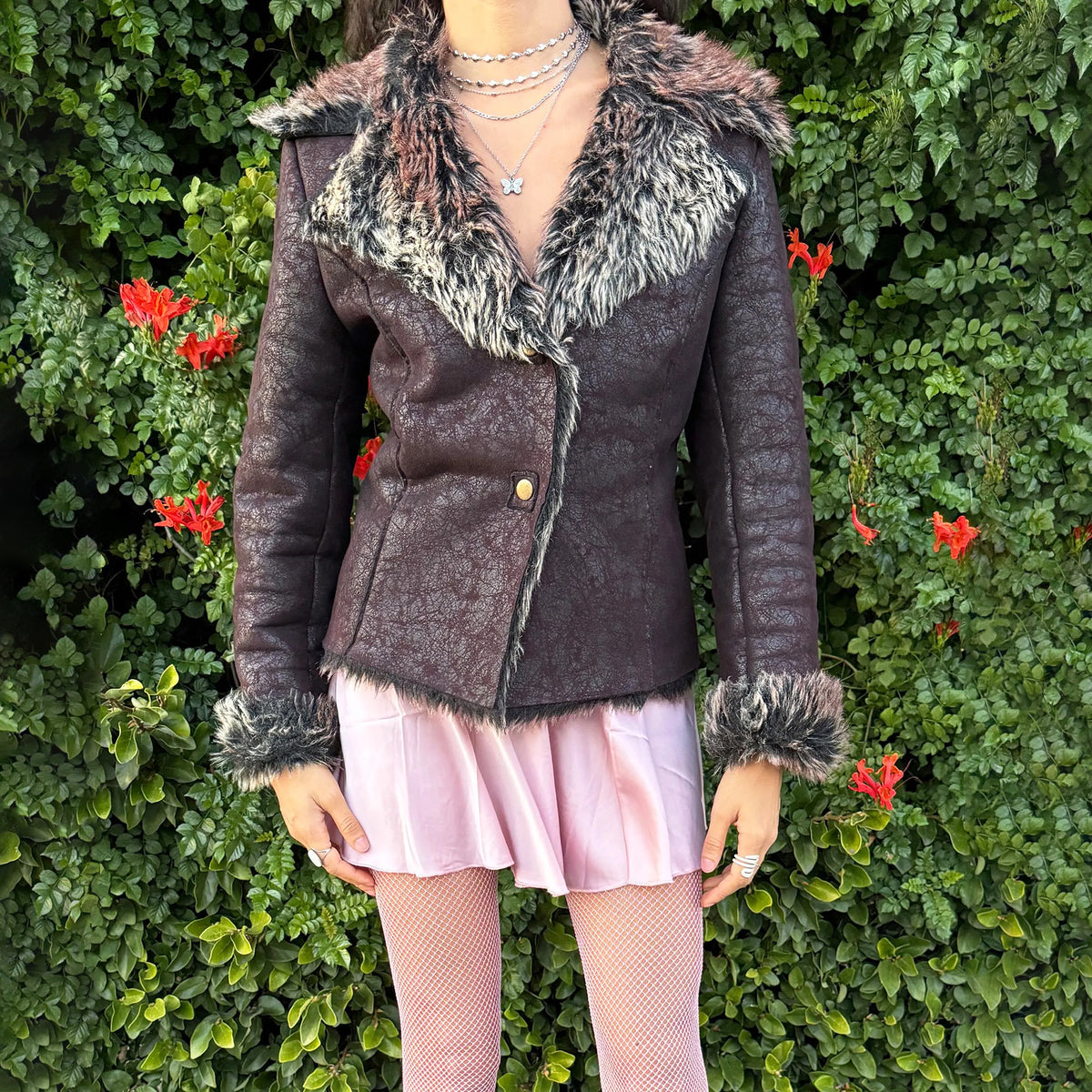 Vintage 2000s fitted jacket in a deep reddish-brown tone, featuring a distressed faux-leather effect and dramatic black, cream, and brown faux-fur trim around the oversized collar, cuffs, and hem. Designed with a sharply fitted waist, curved seam detailing, and snap-button closure for a distinctly Y2K Penny Lane-inspired silhouette. Crafted from an acrylic and polyester blend. From a French brand. Excellent vintage condition.