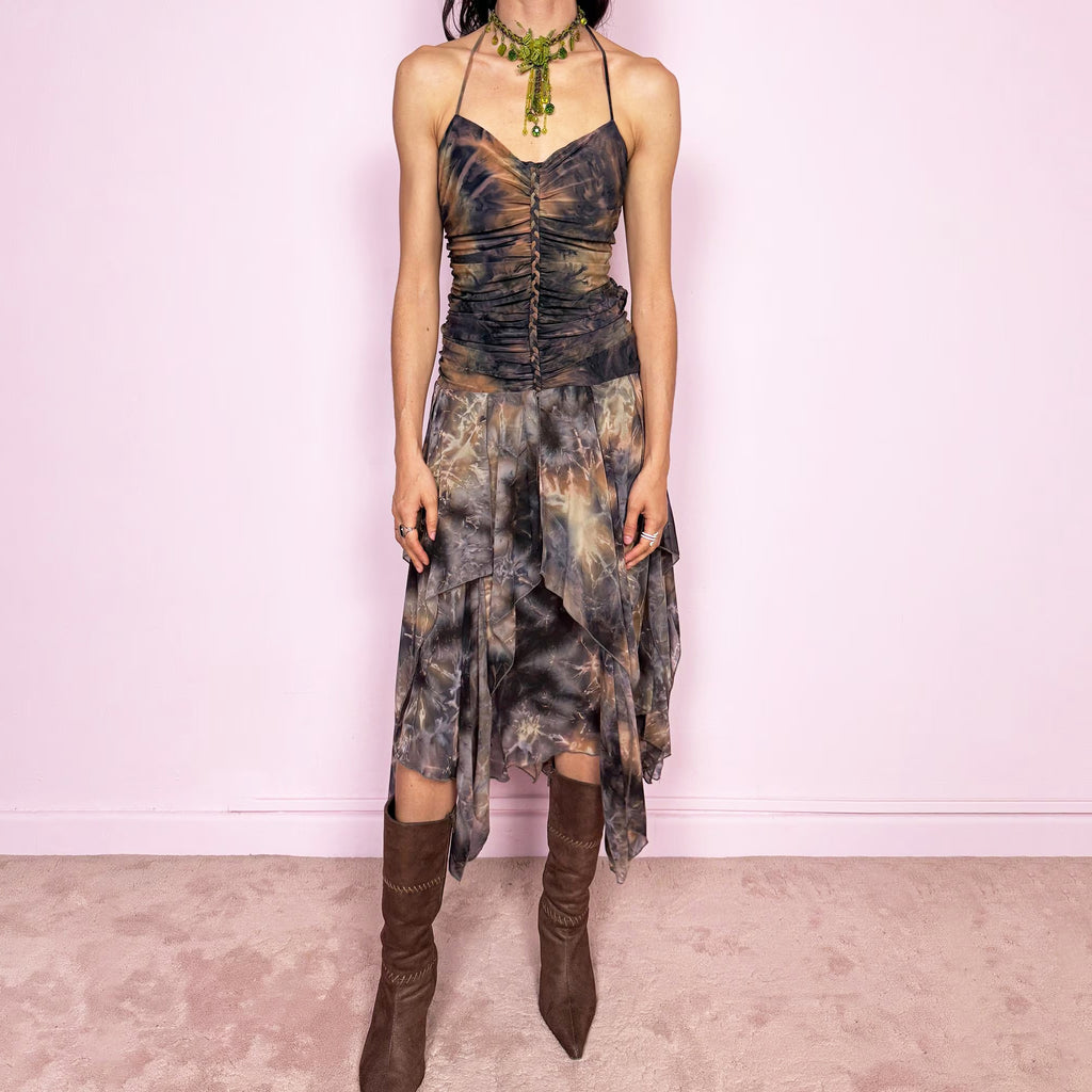 Vintage 2000s multicolored halter midi dress with a tie-neck design and ruched stretchy bodice for a flattering fitted silhouette. Features a dramatic asymmetric handkerchief hem and bold psychedelic tie-dye print in earthy tones. Stunning statement piece perfect for festivals, boho fairy styling, or summer events. Made in USA from polyester. Excellent vintage condition.
