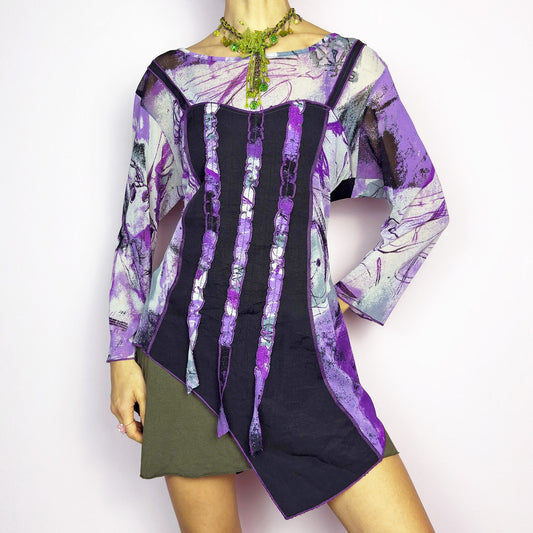The Y2K Mesh Asymmetric Black Top is a vintage 2000s piece featuring a semi-sheer mesh fabric with an abstract purple, black, and white print. Designed with three quarter sleeves and contrast paneling and exposed seams, this top has a deconstructed, edgy aesthetic. The asymmetric hem and raw cut details add a unique touch, making it perfect for grunge or fairycore-inspired outfits. Lightweight and stretchy, ideal for layering and statement looks. Excellent vintage condition.
