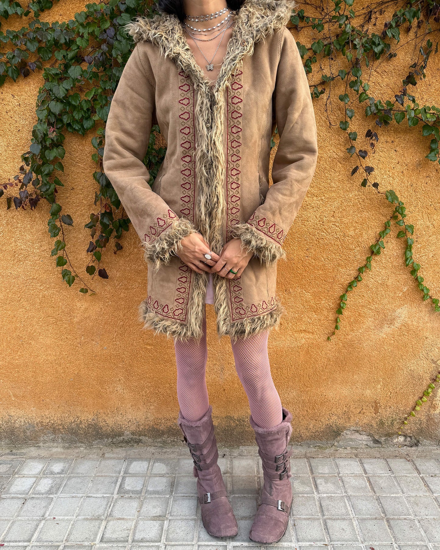 Vintage 2000s beige Penny Lane coat with a 70s boho hippie influence, featuring a hood, faux fur lining and faux fur cuffs. Designed with hook closures, front pockets, and red and brown embroidered details that give it a charming Afghan-inspired look. Warm, cozy, and super cute for winter styling, perfect as an iconic Y2K cold-weather essential. Great vintage condition.