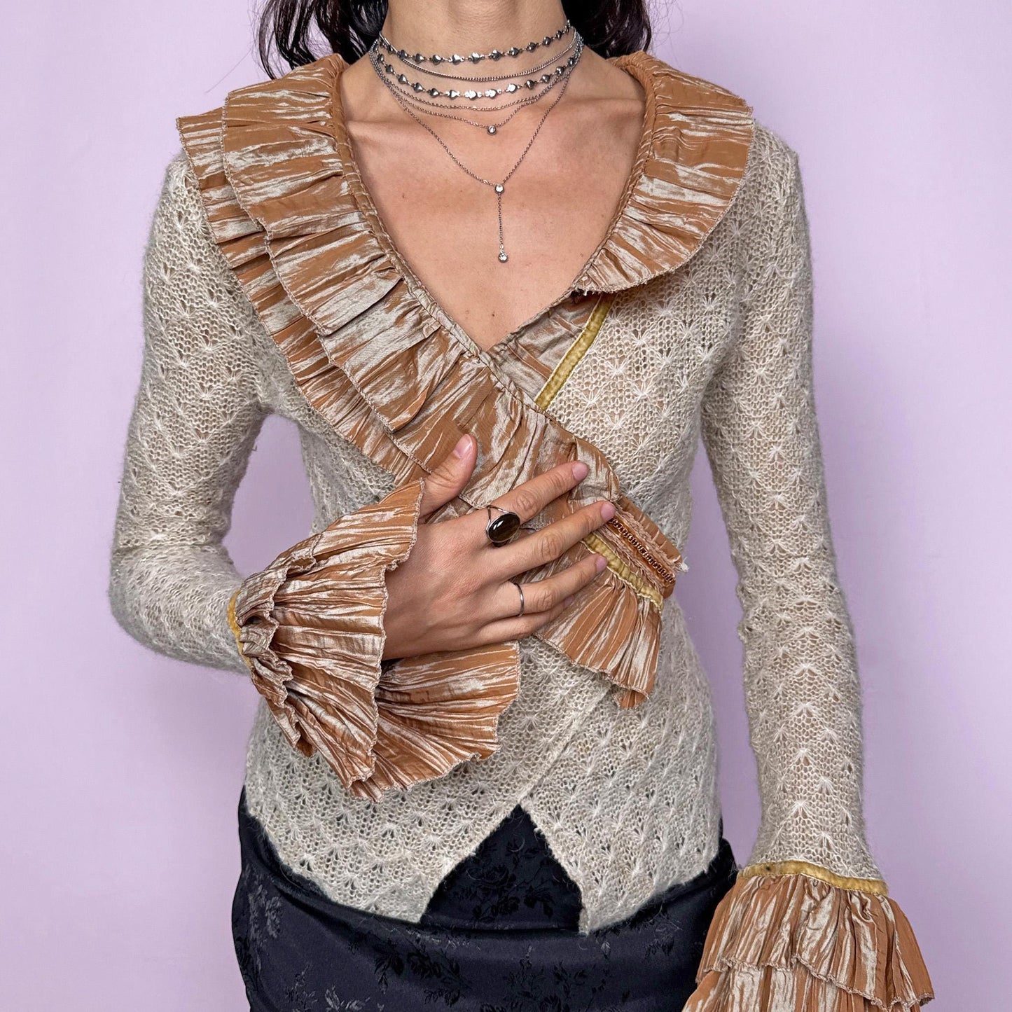 Vintage 2000s beige open-knit wrap cardigan with a dramatic ruffle neckline and tiered mustard-tone ruffle cuffs. Features an elegant tie-back closure, creating a fitted silhouette that highlights the waist. The extravagant design blends romantic, rococo-inspired detailing with a glamorous Y2K formal aesthetic, perfect for event nights, diva moments, or elevated evening styling. Made in France from an acrylic mohair polyester blend. Excellent vintage condition.