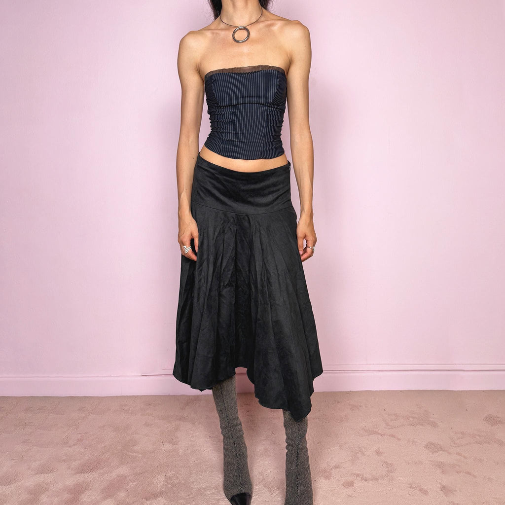 Vintage 2000s black faux suede midi skirt with a dark avant-garde minimal look. Features a softly flared silhouette, asymmetric hem, side zip closure, and structured no-stretch fit. Can be worn mid rise for size S or lower rise for XS. Made from polyester and acetate. Excellent vintage condition.