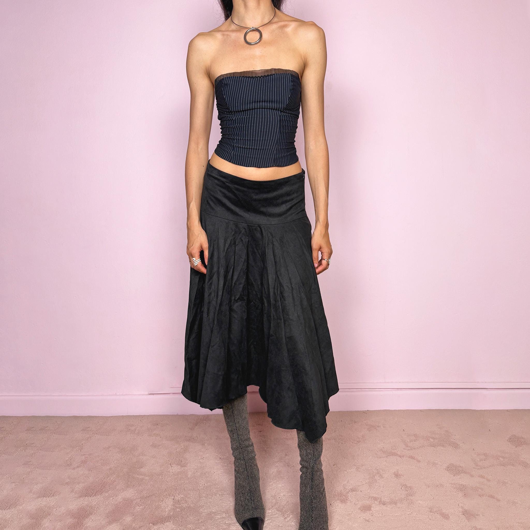 Vintage 2000s black faux suede midi skirt with a dark avant-garde minimal look. Features a softly flared silhouette, asymmetric hem, side zip closure, and structured no-stretch fit. Can be worn mid rise for size S or lower rise for XS. Made from polyester and acetate. Excellent vintage condition.