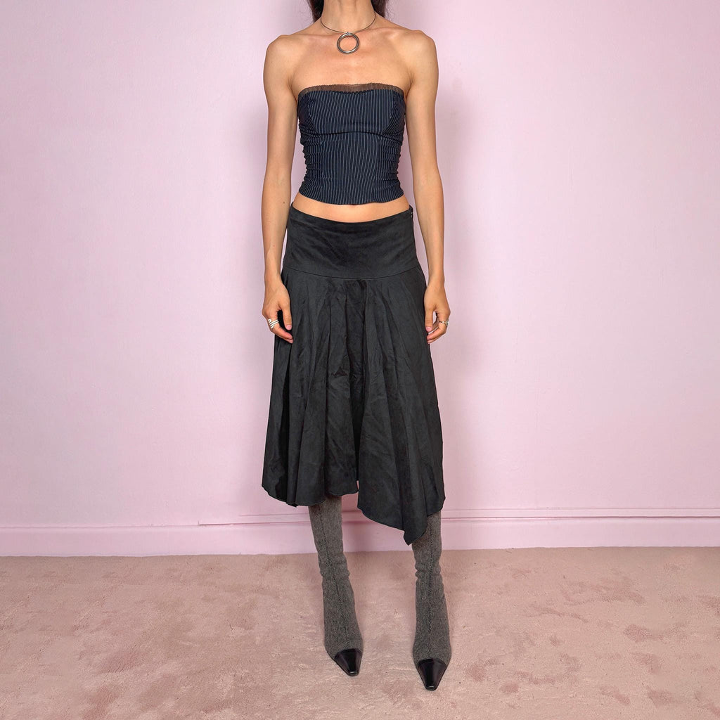 Vintage 2000s black faux suede midi skirt with a dark avant-garde minimal look. Features a softly flared silhouette, asymmetric hem, side zip closure, and structured no-stretch fit. Can be worn mid rise for size S or lower rise for XS. Made from polyester and acetate. Excellent vintage condition.