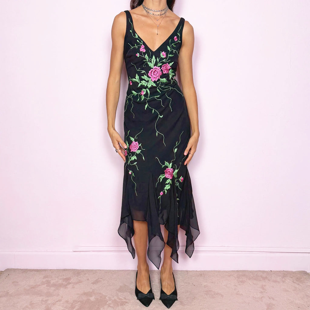 Stunning vintage 2000s black sleeveless V-neck long midi dress featuring pink and green floral embroidered details with beaded accents. The asymmetric handkerchief-style hem adds movement and a romantic statement look, perfect for gala events, formal parties or night occasions. Made from polyester. Excellent vintage condition.