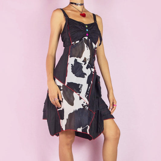 The Y2K Black Mesh Asymmetric Dress is a bold vintage 2000s piece featuring a unique patchwork design with contrast red stitching and colorful button detailing on the front. Made from sheer mesh fabric with adjustable straps, this dress has a playful asymmetrical hemline and patch pockets. Perfect for festivals, parties, or summer casual outings.