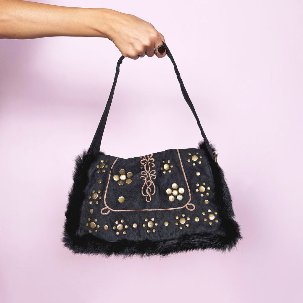 Vintage 2000s dark gray-almost-black shoulder bag featuring soft faux suede and corduroy with black faux fur trim along the flap. The front showcases golden round studded details and brown embroidered accents for a bold boho look. It has a zipper closure and a comfortable shoulder strap, making it a super cute party or night-out statement piece. Designed in France. Excellent vintage condition.