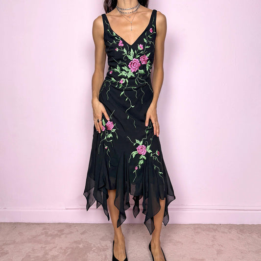 Stunning vintage 2000s black sleeveless V-neck long midi dress featuring pink and green floral embroidered details with beaded accents. The asymmetric handkerchief-style hem adds movement and a romantic statement look, perfect for gala events, formal parties or night occasions. Made from polyester. Excellent vintage condition.