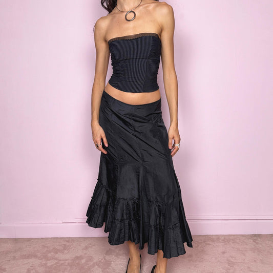 Vintage 2000s black elegant midi skirt featuring a godet-style silhouette with pleated ruffle panels creating a fluid asymmetric flare. Back zip closure with no stretch. Avant garde dark romantic aesthetic, perfect for event, party, or formal wear. Can be worn mid rise for size S or high waisted for size M. Made by a French brand. Great vintage condition.