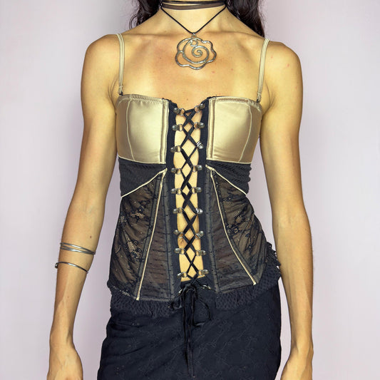 The vintage 2000s black and gold corset is a sculptural lingerie-inspired top with boning, sheer lace side panels, dramatic lace-up front and adjustable straps. Satin-style cups and contrast piping enhance its hourglass silhouette, while the zip back and ruffle hem add seductive structure. Made of polyamide blend, it moves from night-out to bedroom with ease. A collectible Y2K statement for evening looks, clubwear, or layered editorial styling.