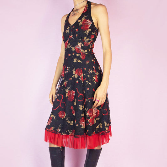 The Y2K Black Halter Lace Midi Dress is a vintage 2000s piece featuring a halter tie neck design, a red floral rose print mesh overlay, and a side zipper closure. Perfect for a summer party or a romantic evening out. Excellent vintage condition.